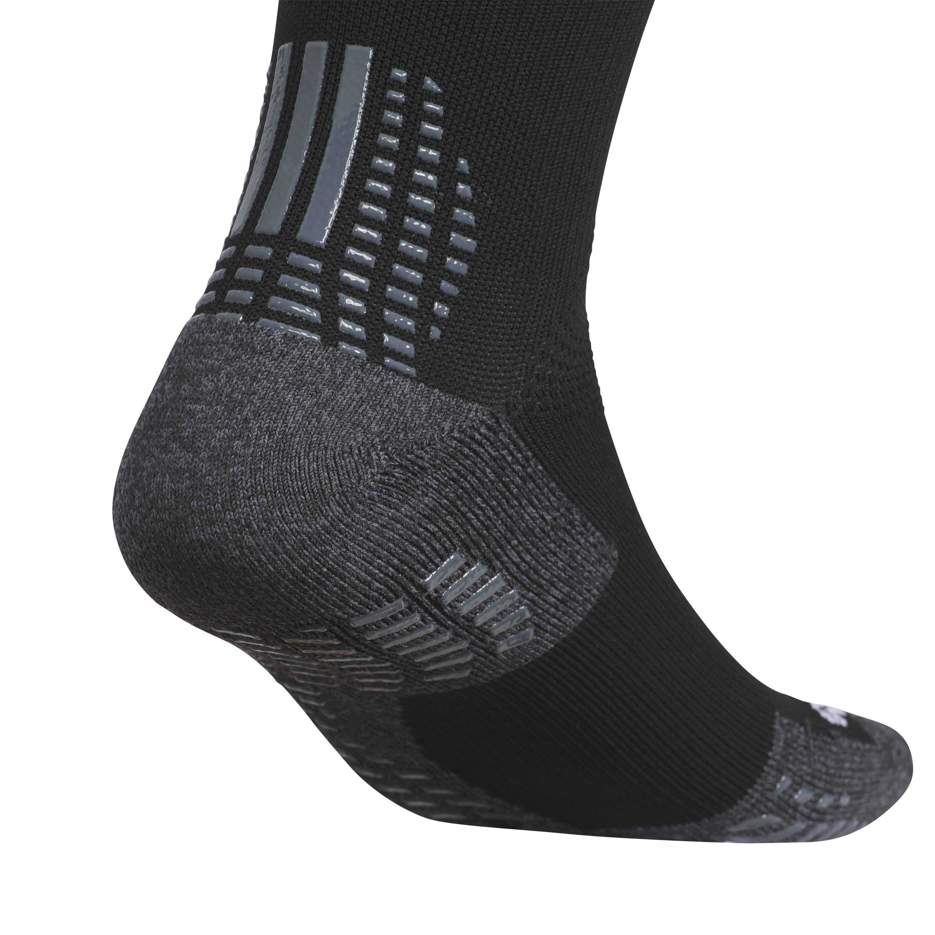 A close-up of a black athletic sock with a dark gray reinforced heel and shiny, light-gray non-slip grip patterns on the back and bottom for traction.
