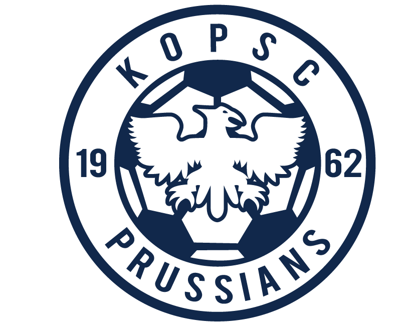 A circular navy blue KOPSC Prussians crest on a black background, featuring a central eagle over a soccer ball with the year 1962.
