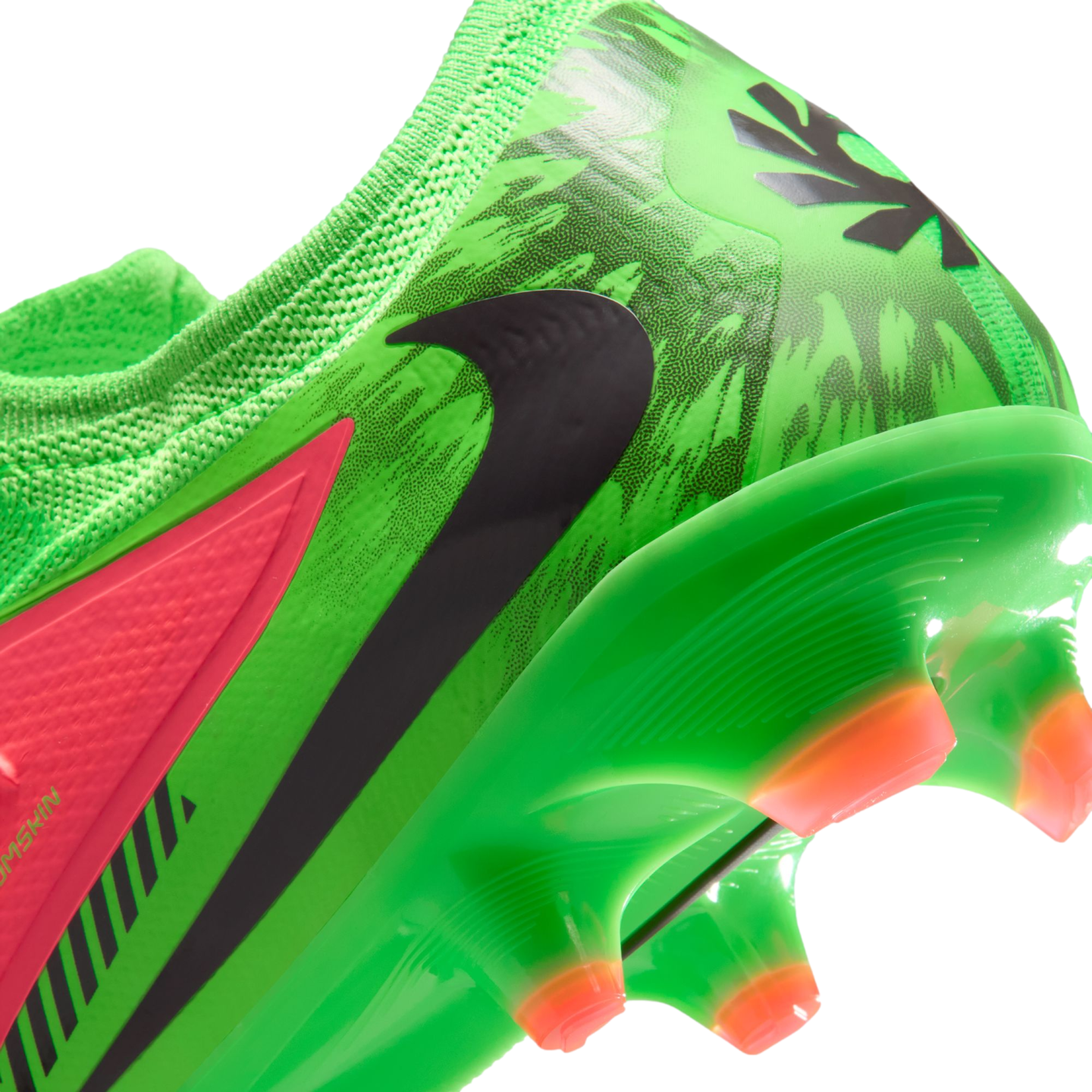 A close-up view of the heel and soleplate of a vibrant green Nike soccer cleat with a black swoosh, a neon pink accent panel, and orange-tipped studs against a black background.