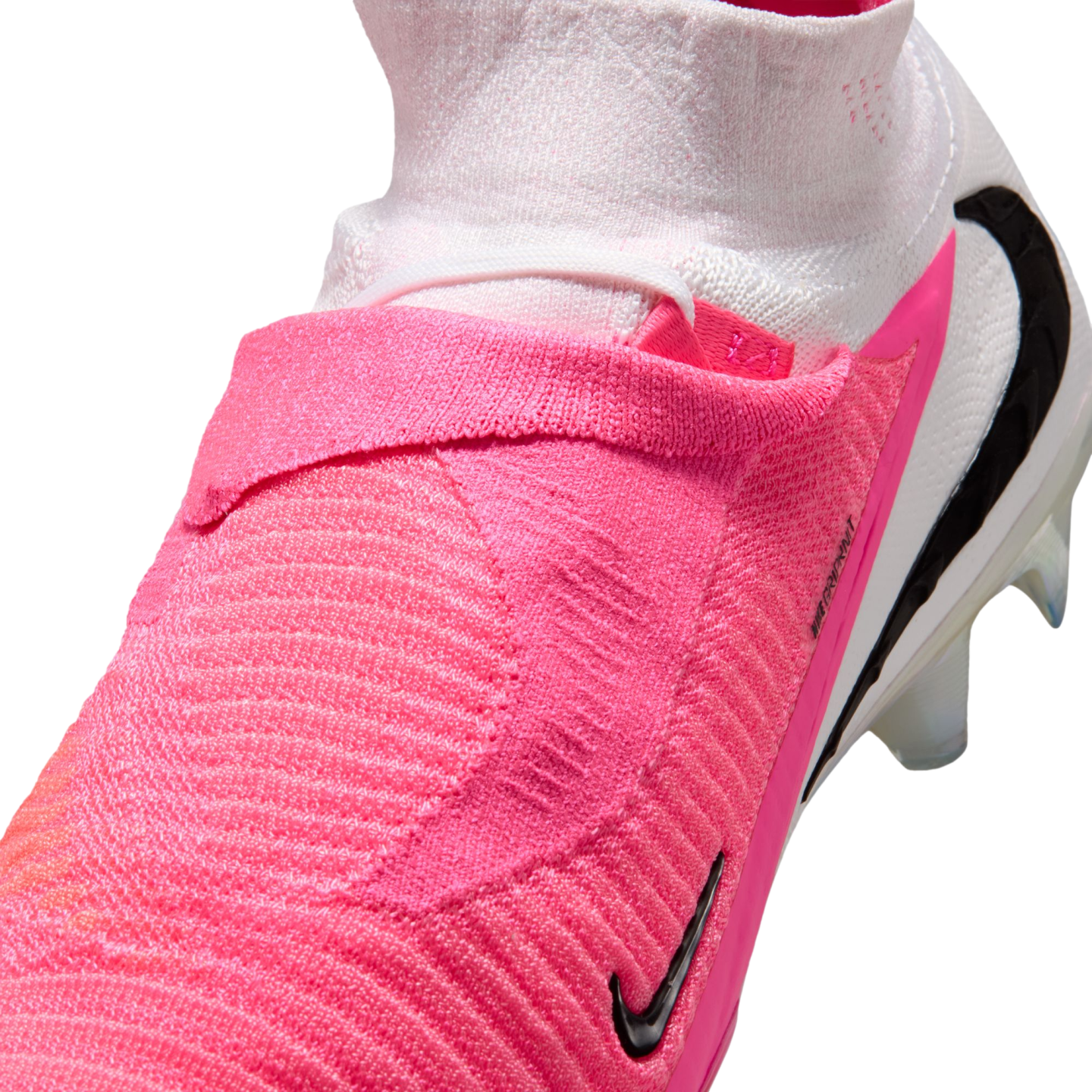 Close-up of a pink and white Nike soccer cleat featuring a textured upper and a high-top sock-like collar.