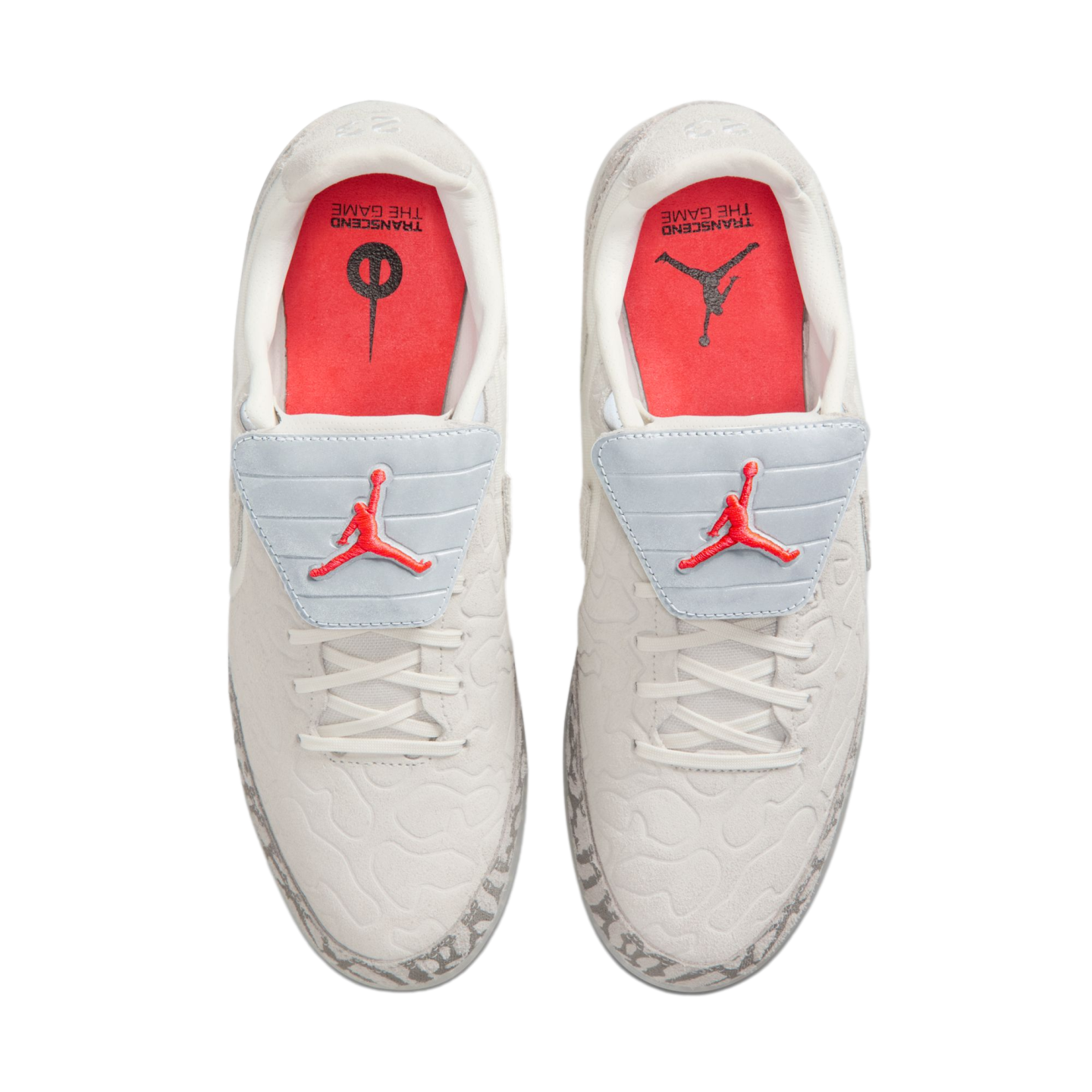 A top-down view of white sneakers featuring light blue tongue covers with red Jumpman logos and orange insoles, set against a solid black background.