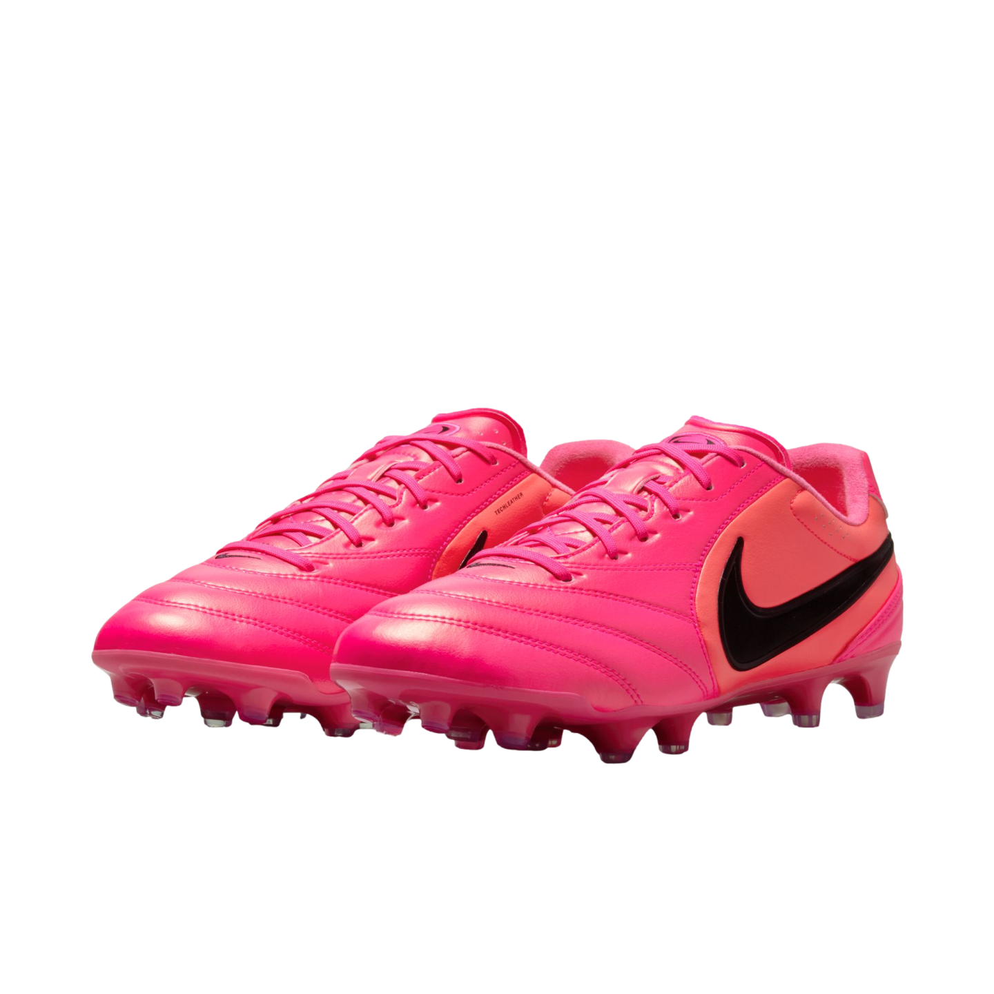 A pair of bright pink Nike soccer cleats with black swooshes on a white background.