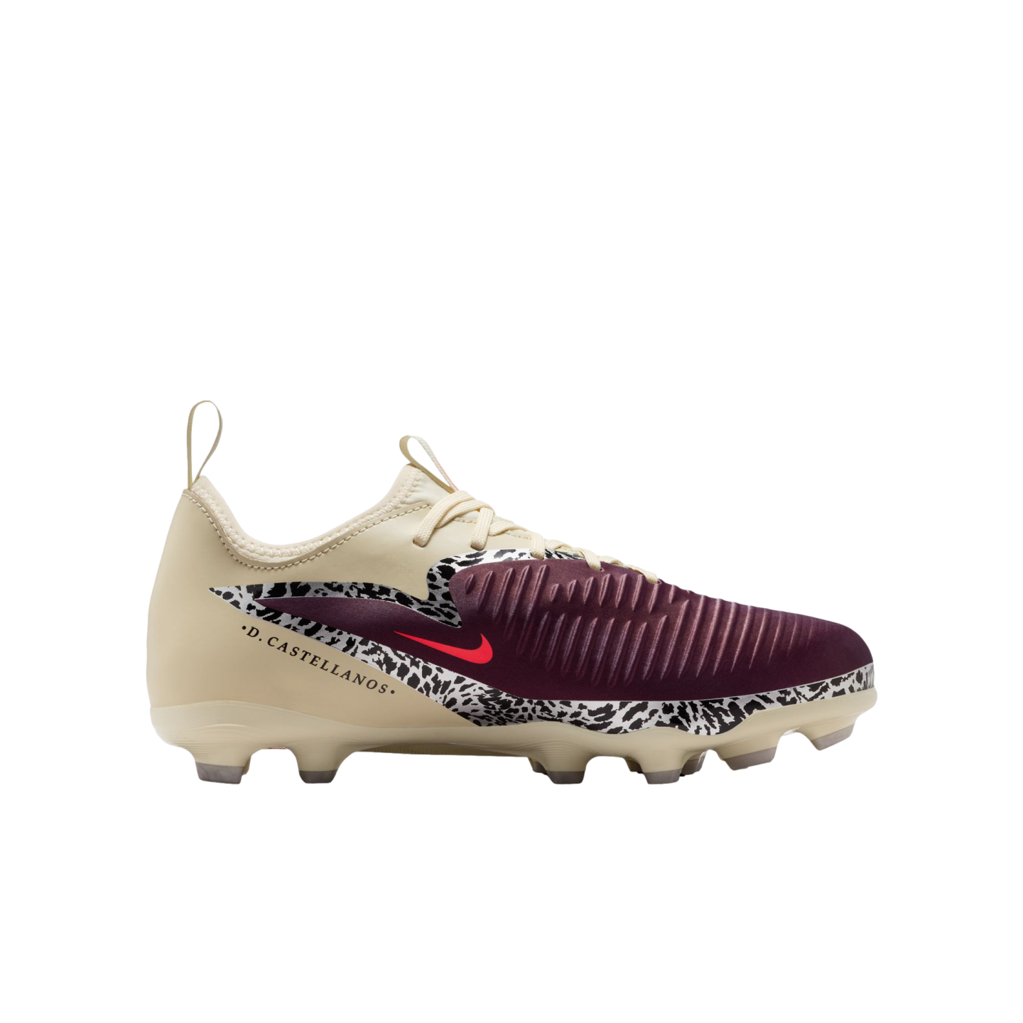 A profile view of a Nike soccer cleat against a solid black background. The shoe features a cream-colored upper, a maroon ribbed toe, and a black-and-white speckled pattern across the mid-section with a small red Nike swoosh. The name ".D. CASTELLANOS." is printed in black on the side of the heel.