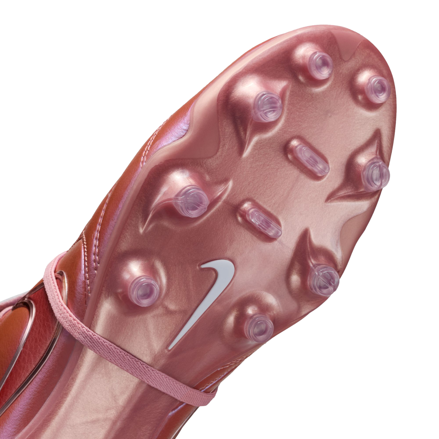 Close-up of a metallic pink Nike soccer cleat soleplate with clear plastic studs and a white swoosh logo against a black background.