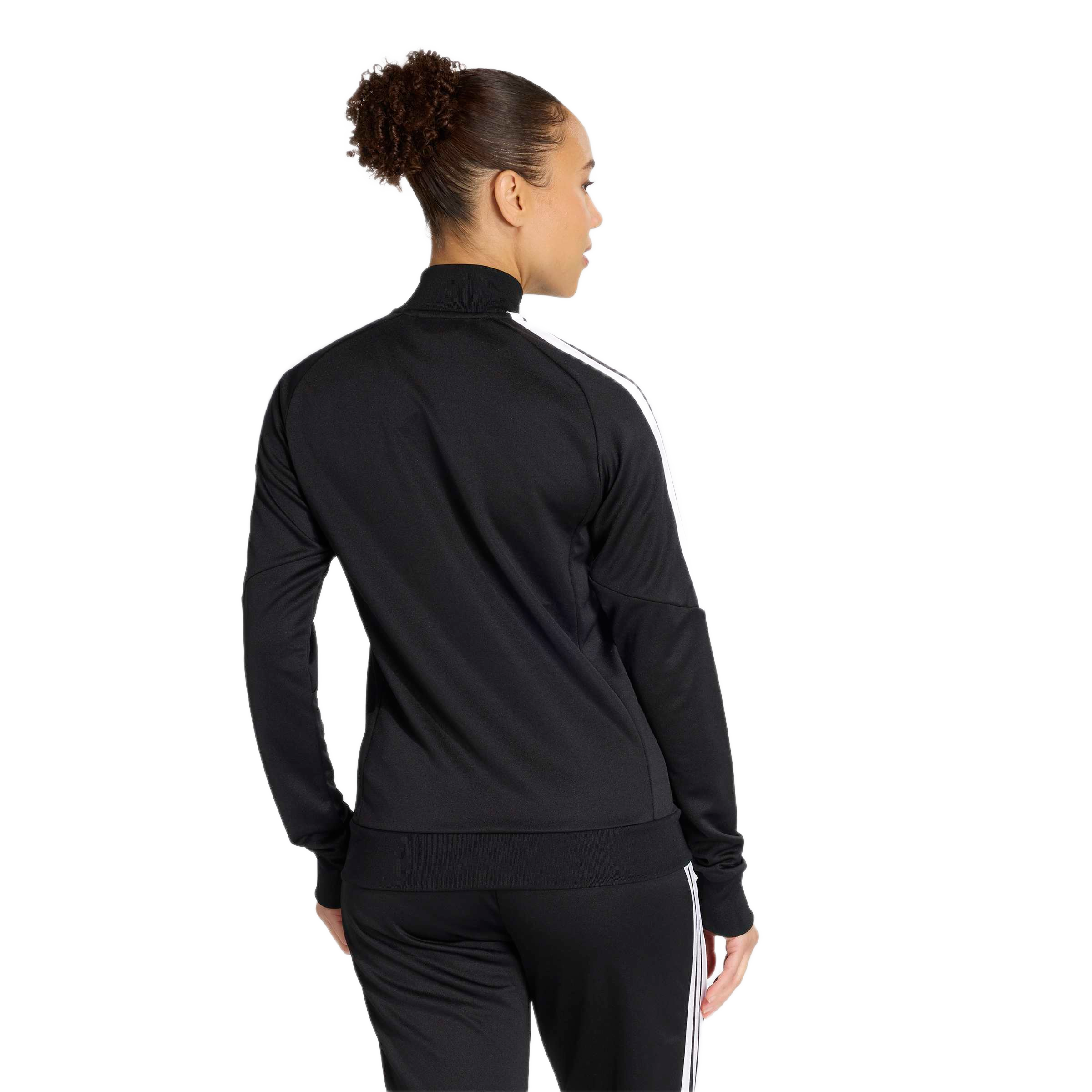 A person seen from behind wears a black athletic jacket with white stripes on the sleeves and matching black pants. Their dark hair is pulled back into a high bun.