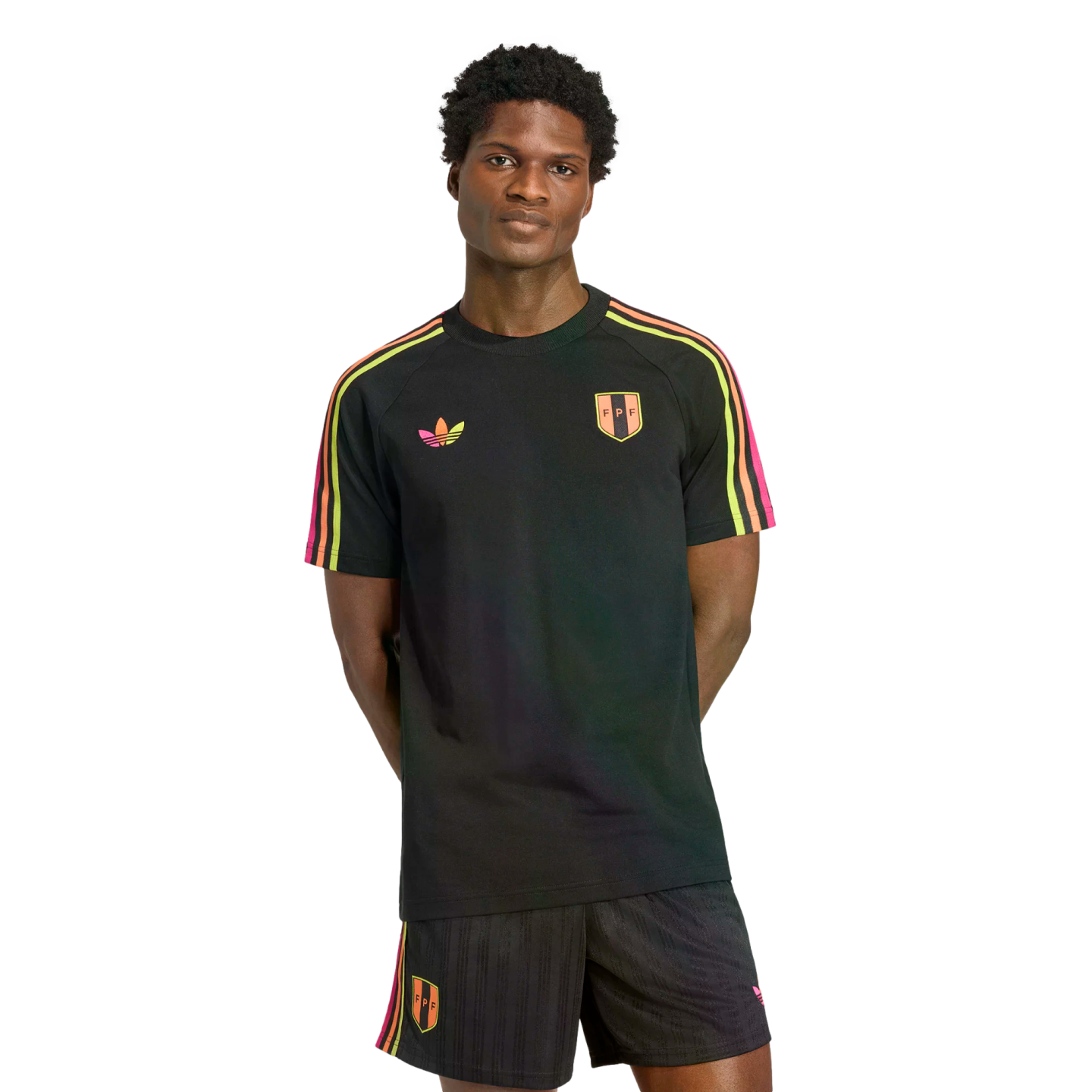 A man models a black Adidas kit with neon pink, orange, and yellow stripes and FPF crests on a black background.