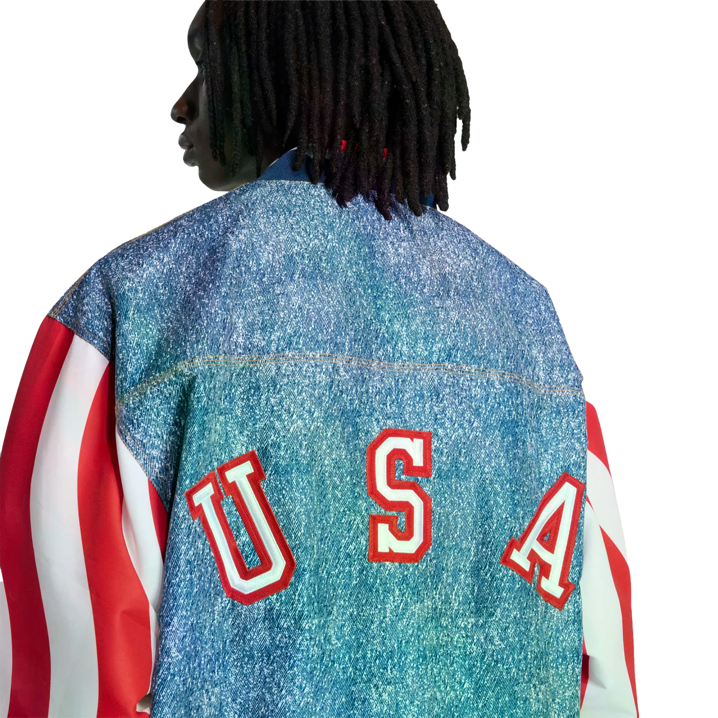 Back view of a person with dreadlocks wearing a denim jacket with red and white striped sleeves and large red "USA" lettering across the back.
