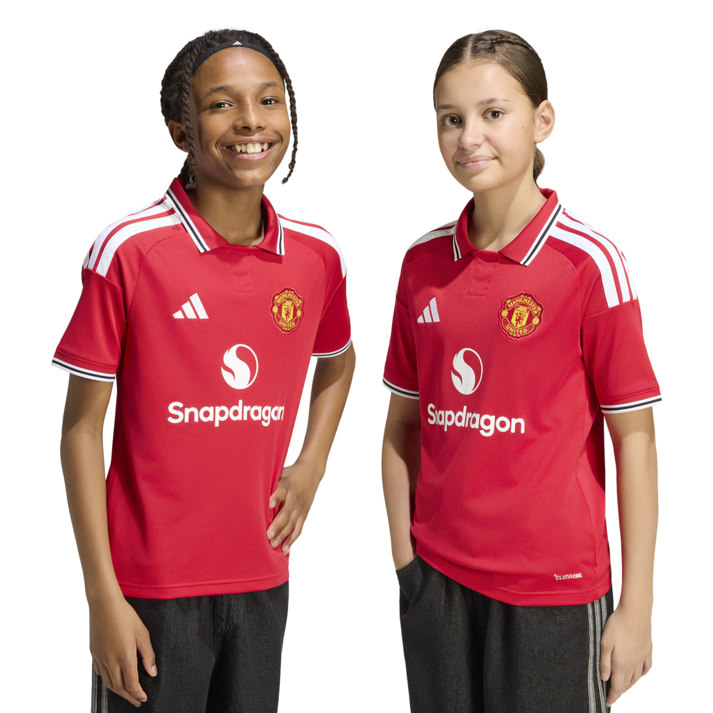 Two children smile in matching red Manchester United football jerseys with the Snapdragon logo against a white background.