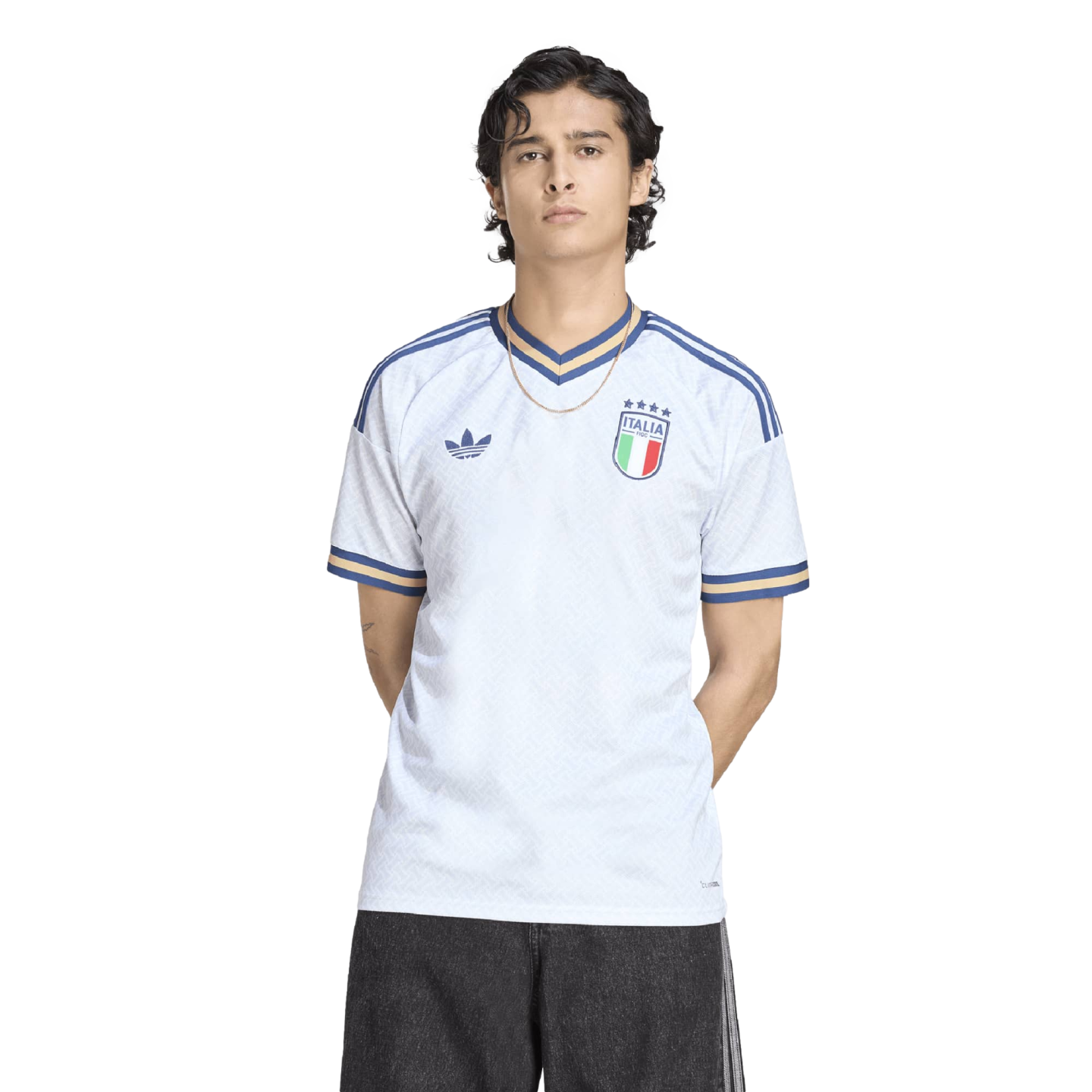 A man in a white Adidas Italy jersey with blue and gold trim, standing against a black background.