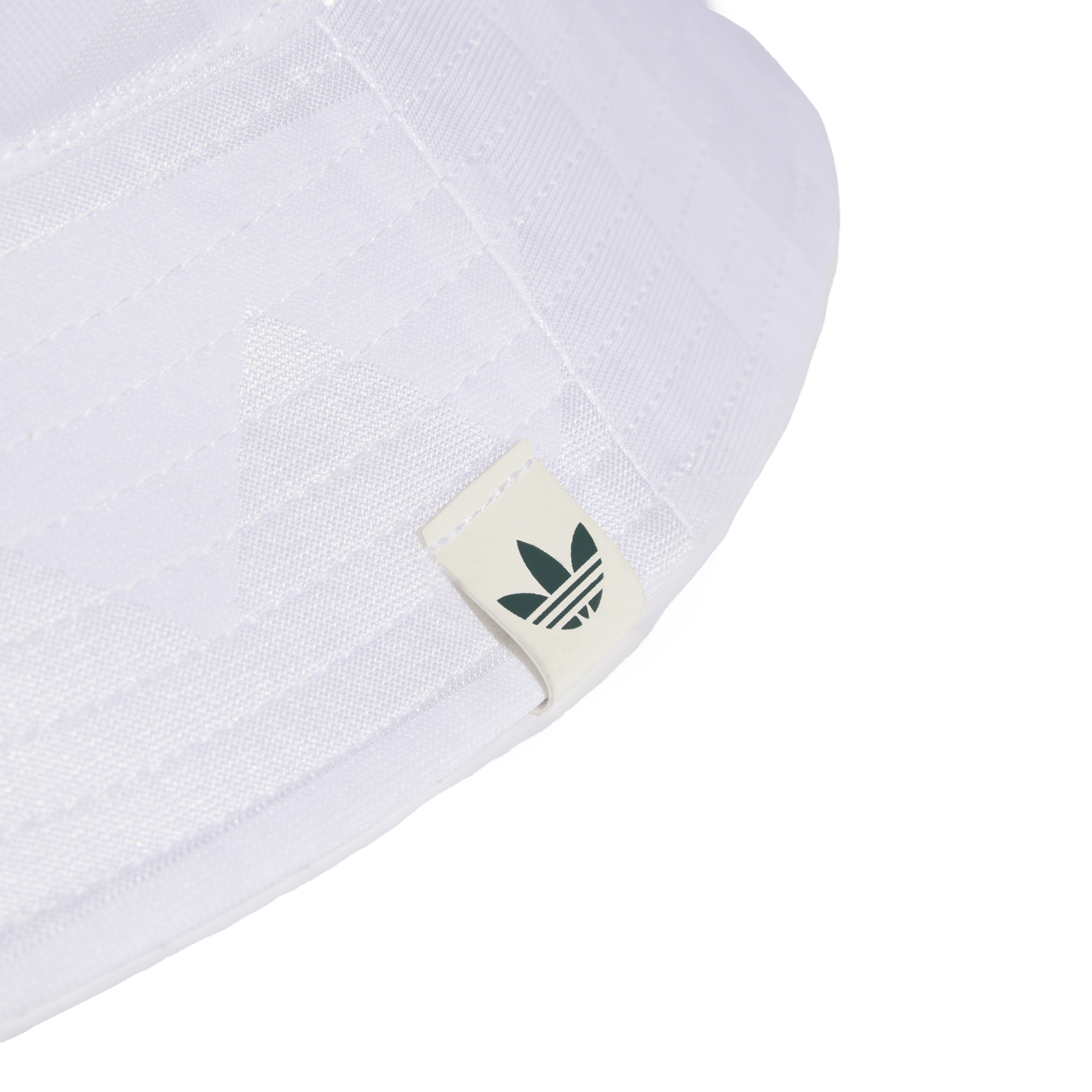 Close-up of the brim of a white bucket hat featuring a small off-white tag with a dark green Adidas Trefoil logo. Set against a solid black background.