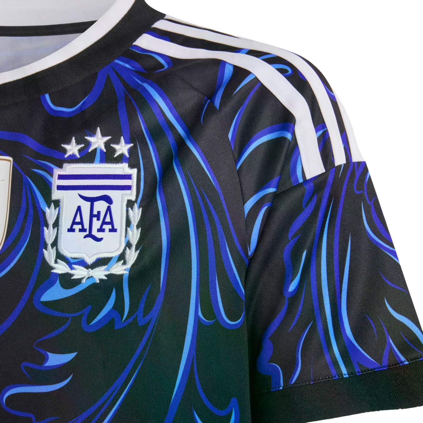 Close-up of an Argentina soccer jersey featuring a black and blue swirling pattern, white shoulder stripes, and the AFA crest with three stars.