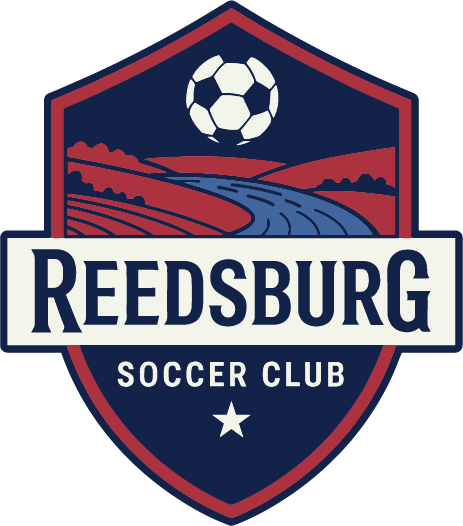 Shield-shaped Reedsburg Soccer Club logo with a soccer ball, red hills, and a blue river. A white banner displays "REEDSBURG," with "SOCCER CLUB" and a star below.