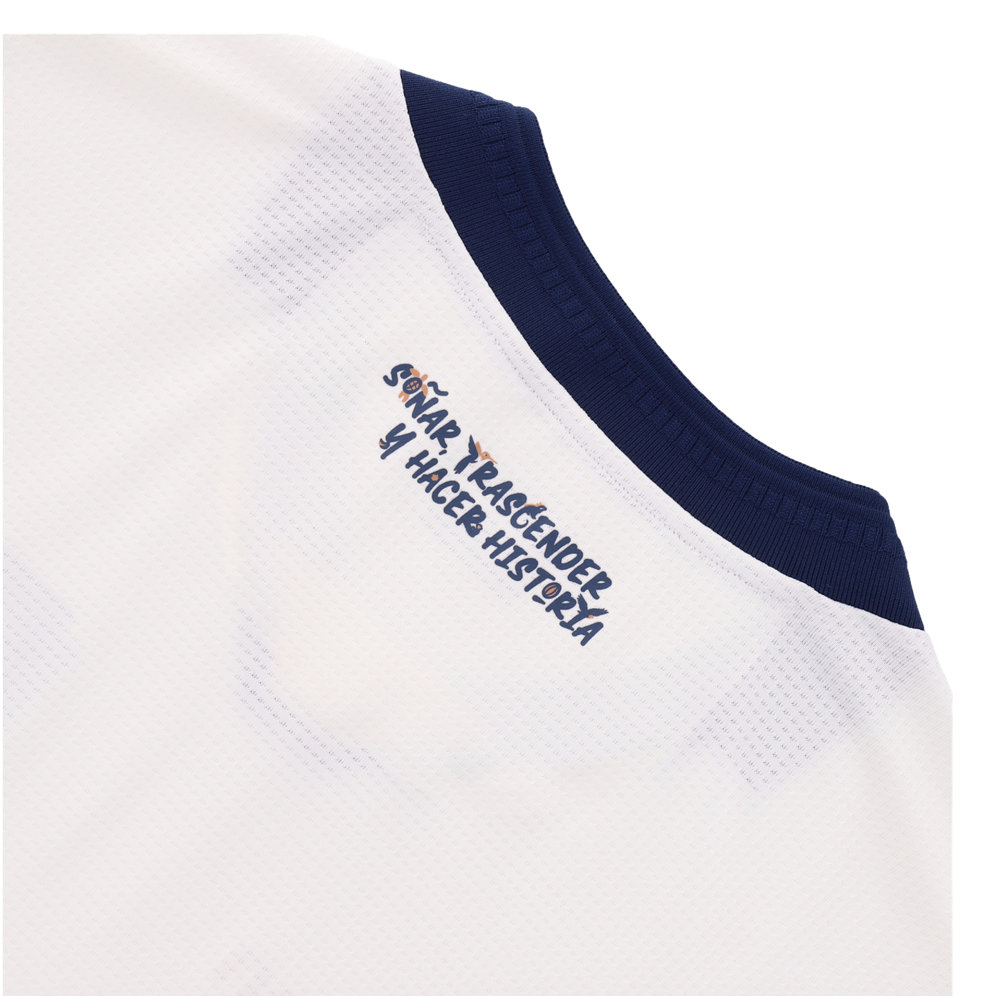 A close-up of a white textured sports jersey featuring a navy blue ribbed collar. Printed on the jersey is the Spanish phrase "SOÑAR, TRASCENDER Y HACER HISTORIA" in a stylized dark blue font, which incorporates small icons of a turtle, a bird, and a soccer ball.