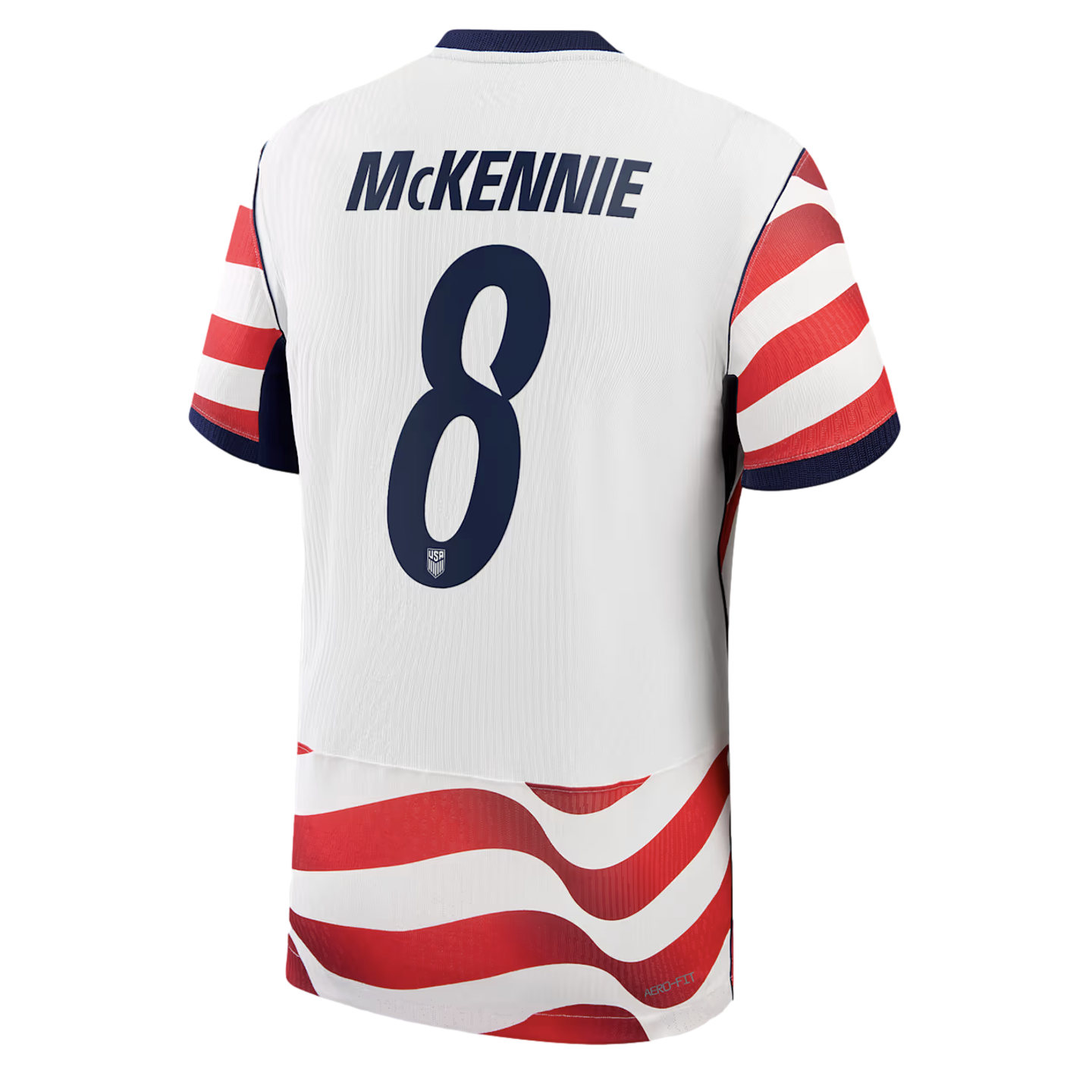 Back view of a white USA soccer jersey with "MCKENNIE" and number 8 in navy. Red and white wavy stripes accent the sleeves and bottom.