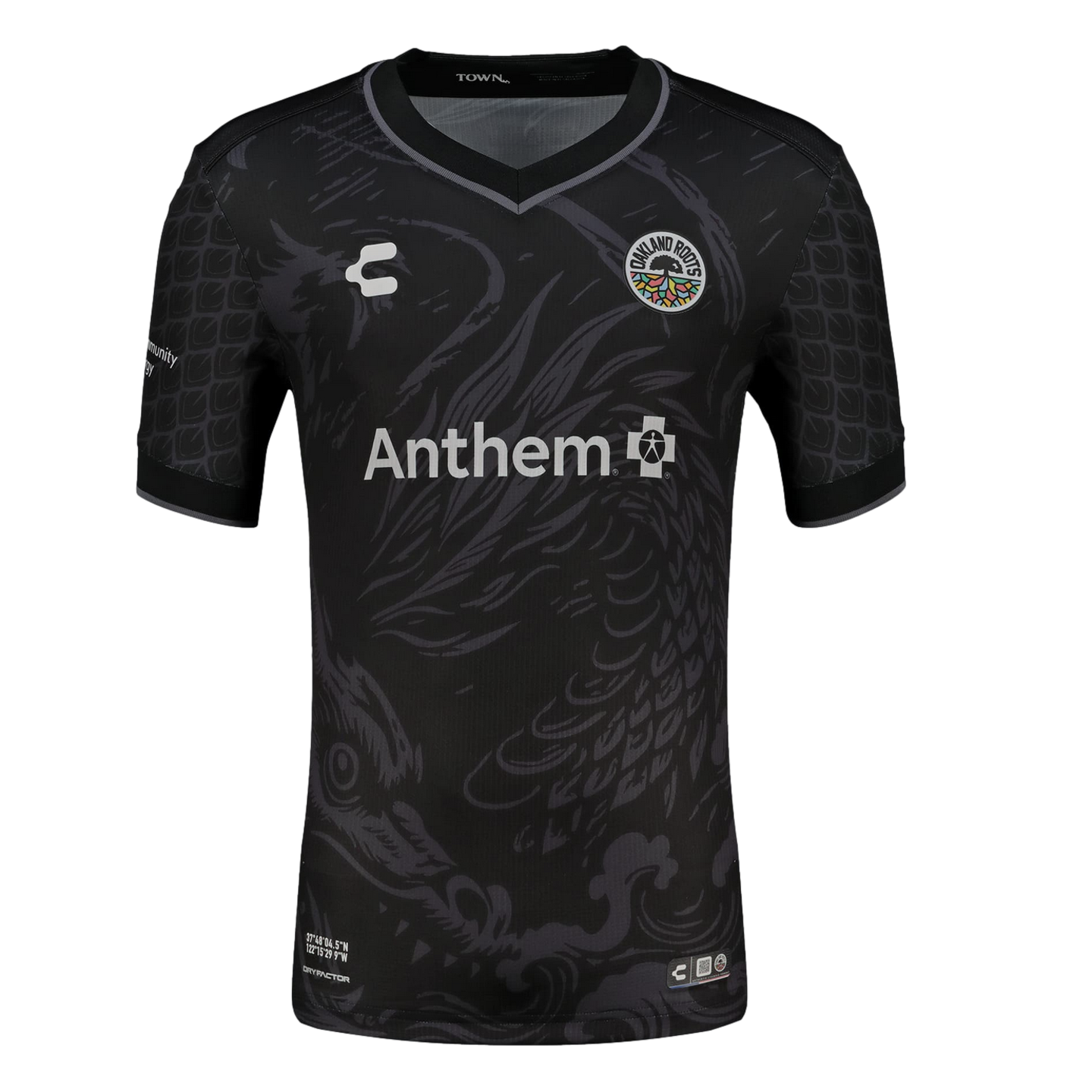 A black short-sleeved soccer jersey featuring a large, subtle grey dragon illustration across the front. The jersey includes the colorful Oakland Roots SC crest on the chest, a white Anthem sponsor logo in the center, and a repeating grey scale pattern on the sleeves.