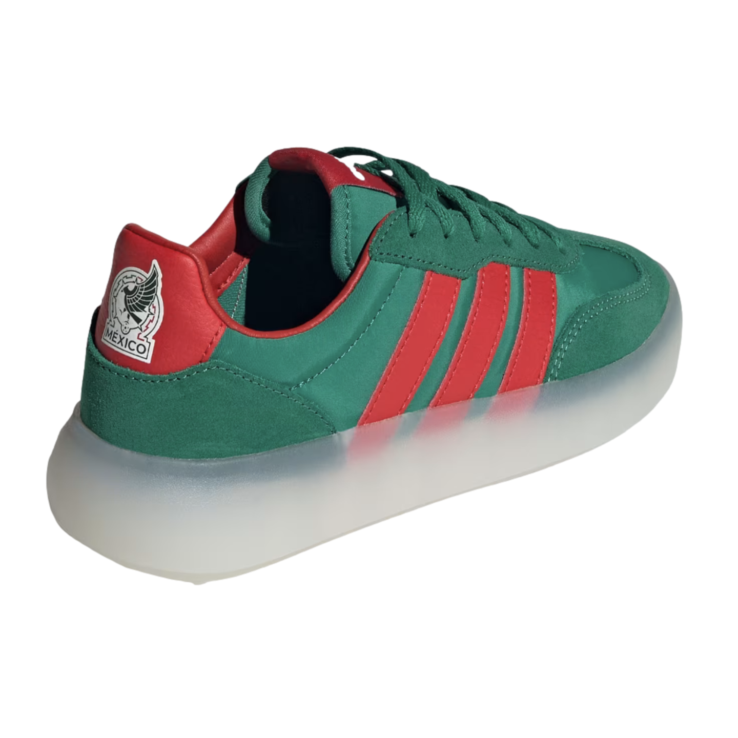 A three-quarter rear view of a green Adidas sneaker featuring red stripes and a thick, translucent white platform sole. The red heel tab is adorned with the Mexico national football team's eagle crest and the word "MÉXICO."