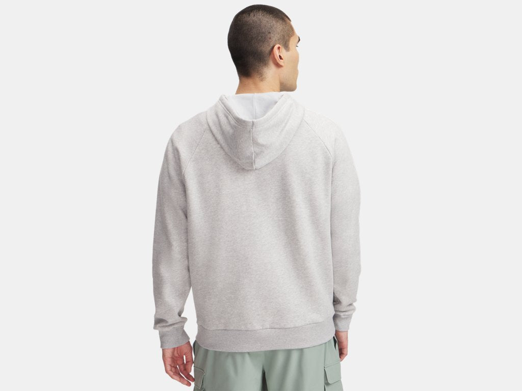 Rear view of a man wearing a light grey hoodie and sage green cargo shorts, standing against a plain background.