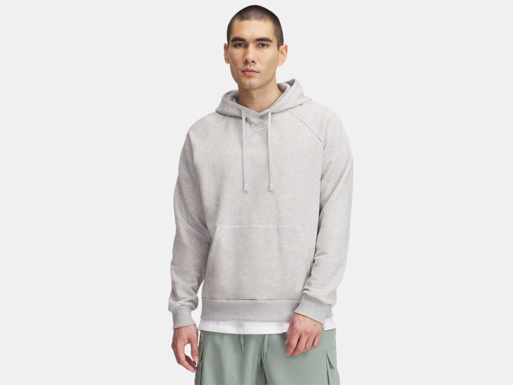 A man wearing a light gray heathered hoodie and sage green cargo pants stands against a plain light background.