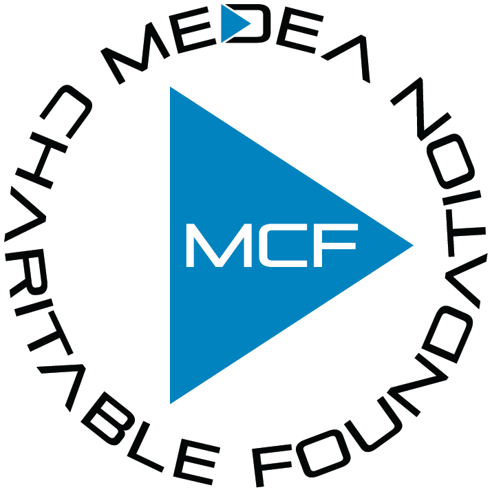 A circular logo for Medea Circle featuring a large blue right-pointing triangle with white "MCF" text inside. The words "MEDEA CHARITABLE FOUNDATION" encircle the triangle in a modern, black, stylized font.