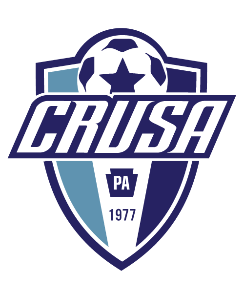 Logo for CRU10 - CRUSA "CREST" POCKET Color, featuring a shield-shaped crest with light blue, white, and dark blue vertical stripes. A soccer ball with a central star is at the top, and the word "CRUSA" is written in bold, white, slanted letters across the middle. Below the name is a dark blue Pennsylvania keystone with "PA" and the year "1977."
