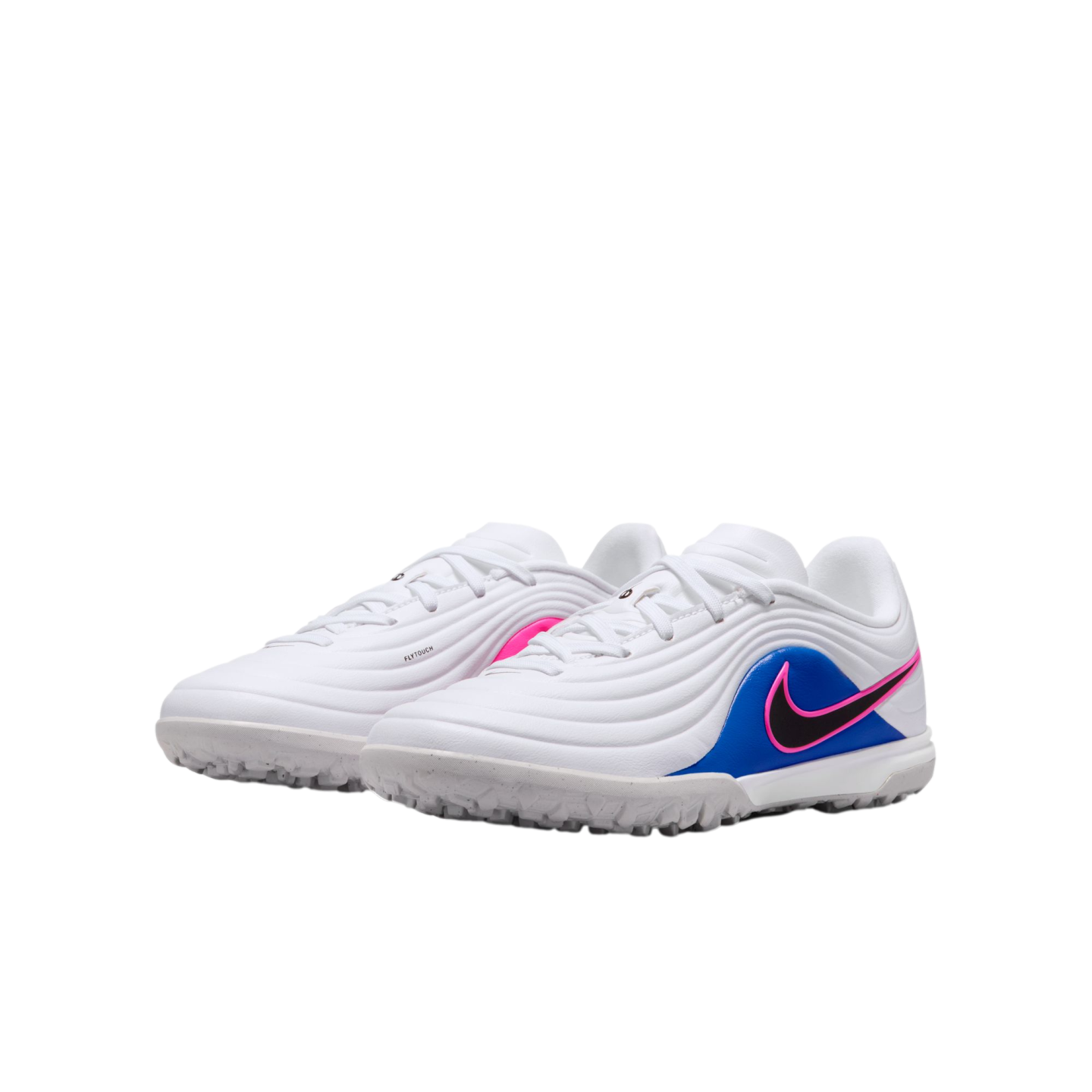 A pair of white Nike turf soccer shoes with a textured upper, blue side panels, and a black Swoosh outlined in pink, set against a black background.