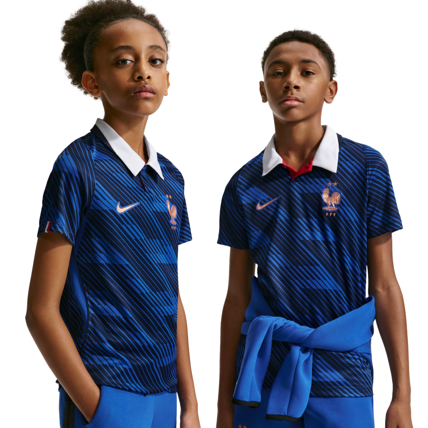 Two youths wear blue France national team jerseys with white collars and diagonal stripes. The shirts feature the FFF rooster crest. Solid black background.