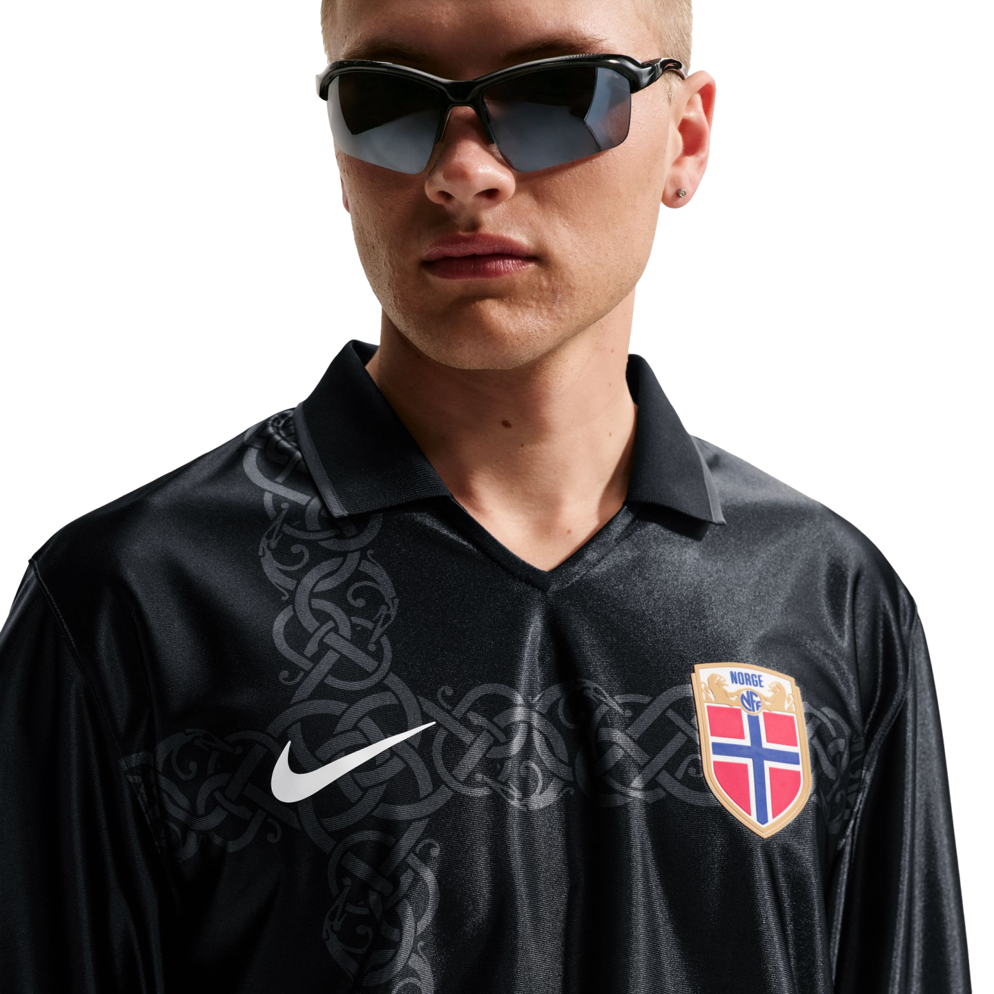 A man in sunglasses wears a black long-sleeved Nike Norway jersey featuring a grey celtic pattern, set against a white background.
