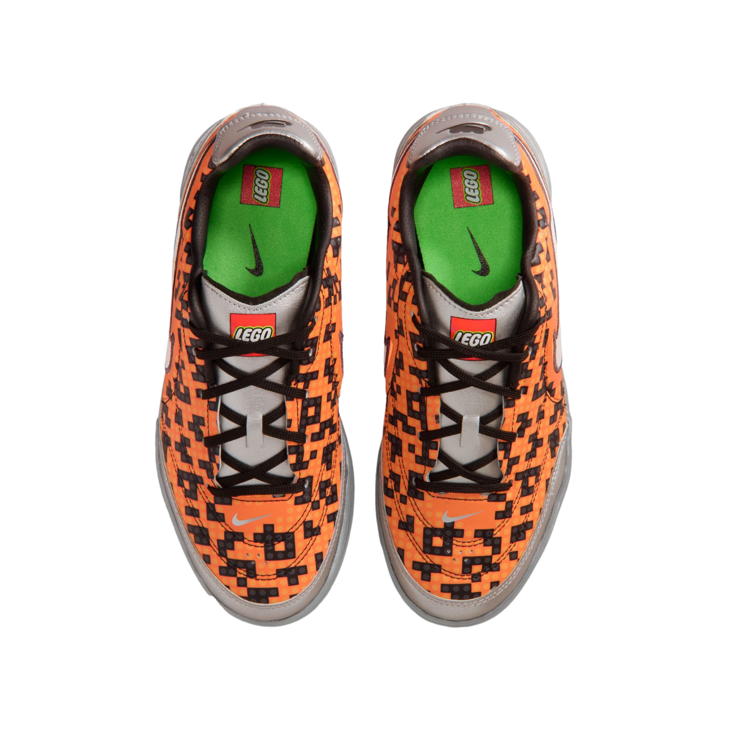 Top-down view of orange Nike sneakers with a black pixelated LEGO pattern, silver accents, and green insoles, featuring both Nike and LEGO branding.