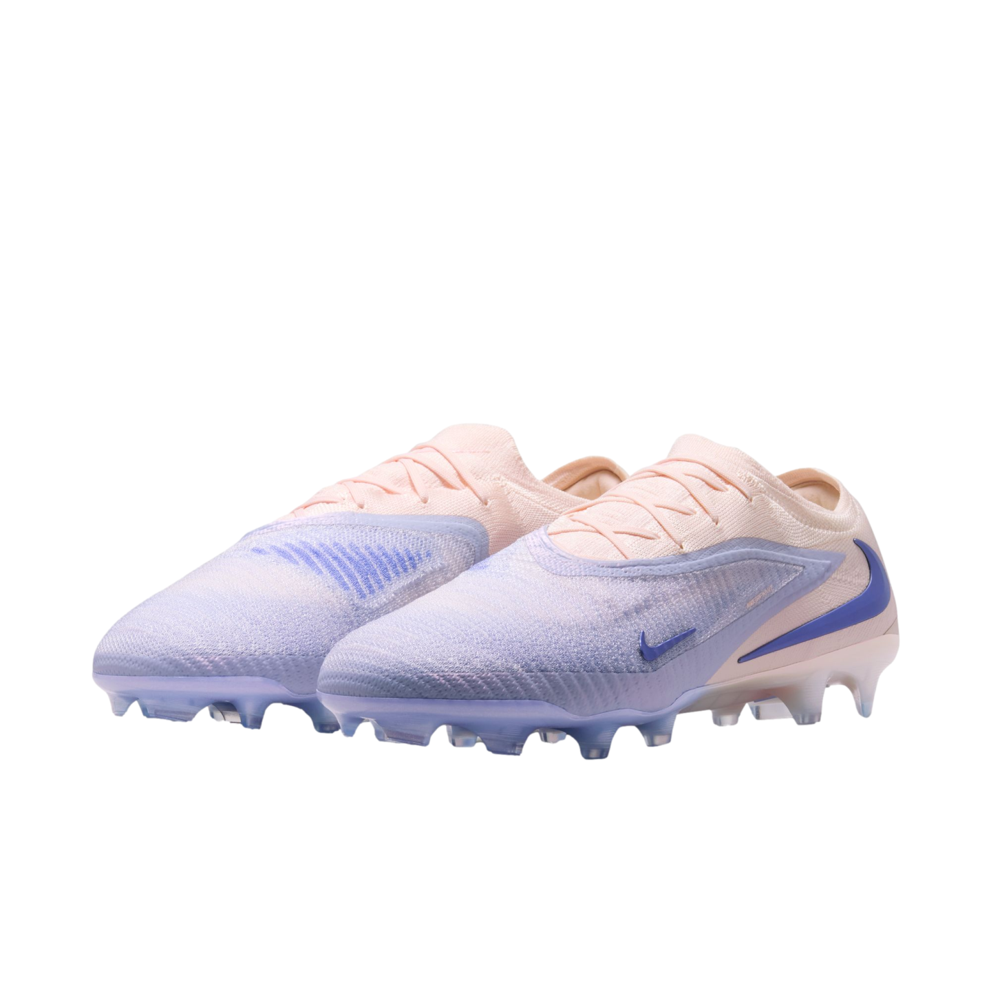 A pair of Nike soccer cleats in a pale pink and lavender gradient with blue accents on a black background.