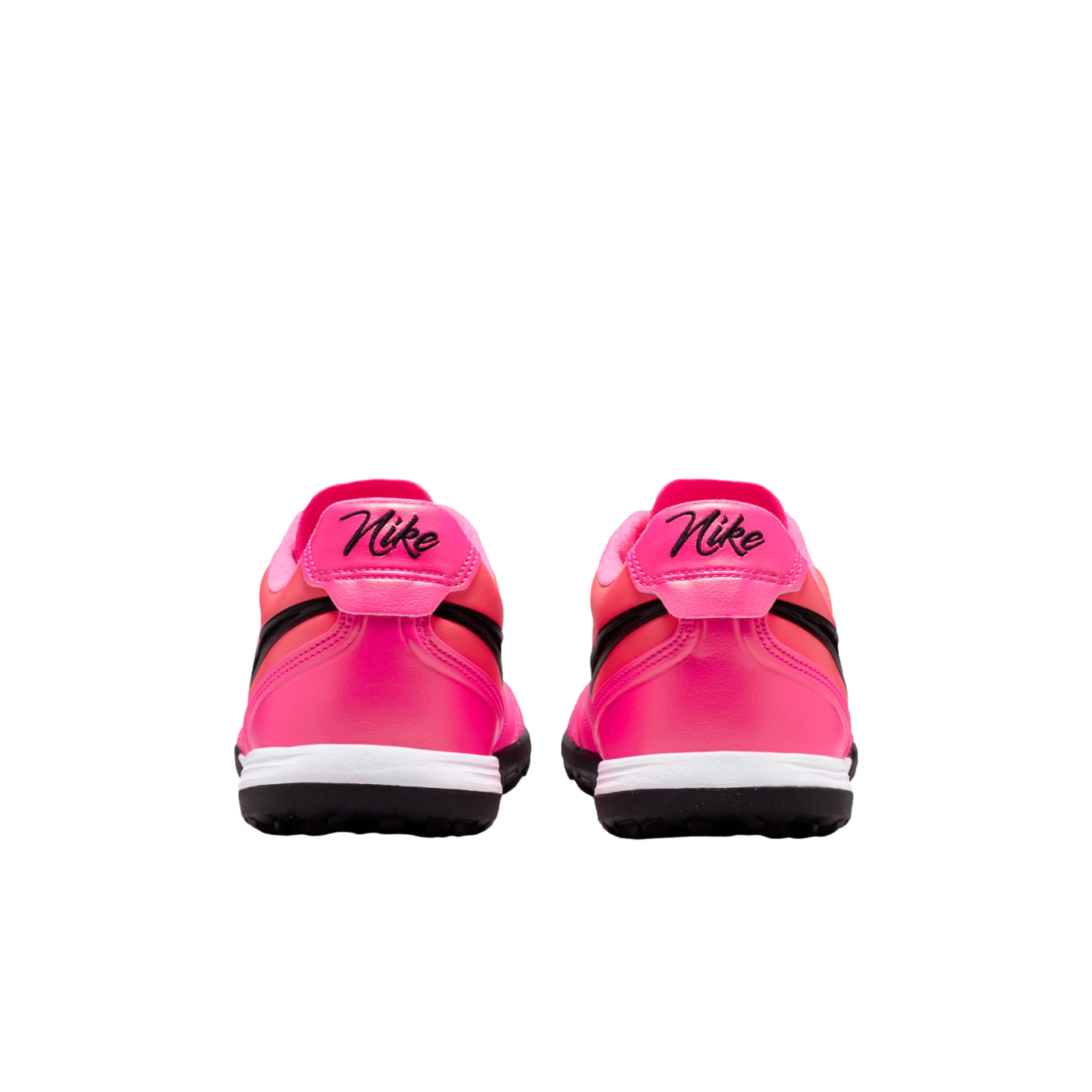 Back view of a pair of bright pink Nike sneakers with black cursive logos on the heels, white midsoles, and black outsoles against a white background.