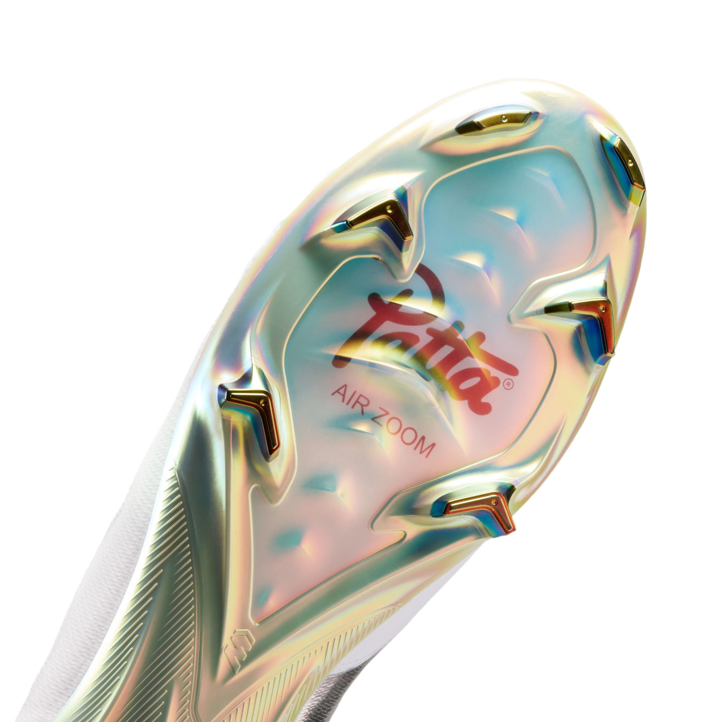 Close-up of the iridescent sole of a white soccer cleat featuring a red Patta logo, "AIR ZOOM" text, and gold-tipped studs.