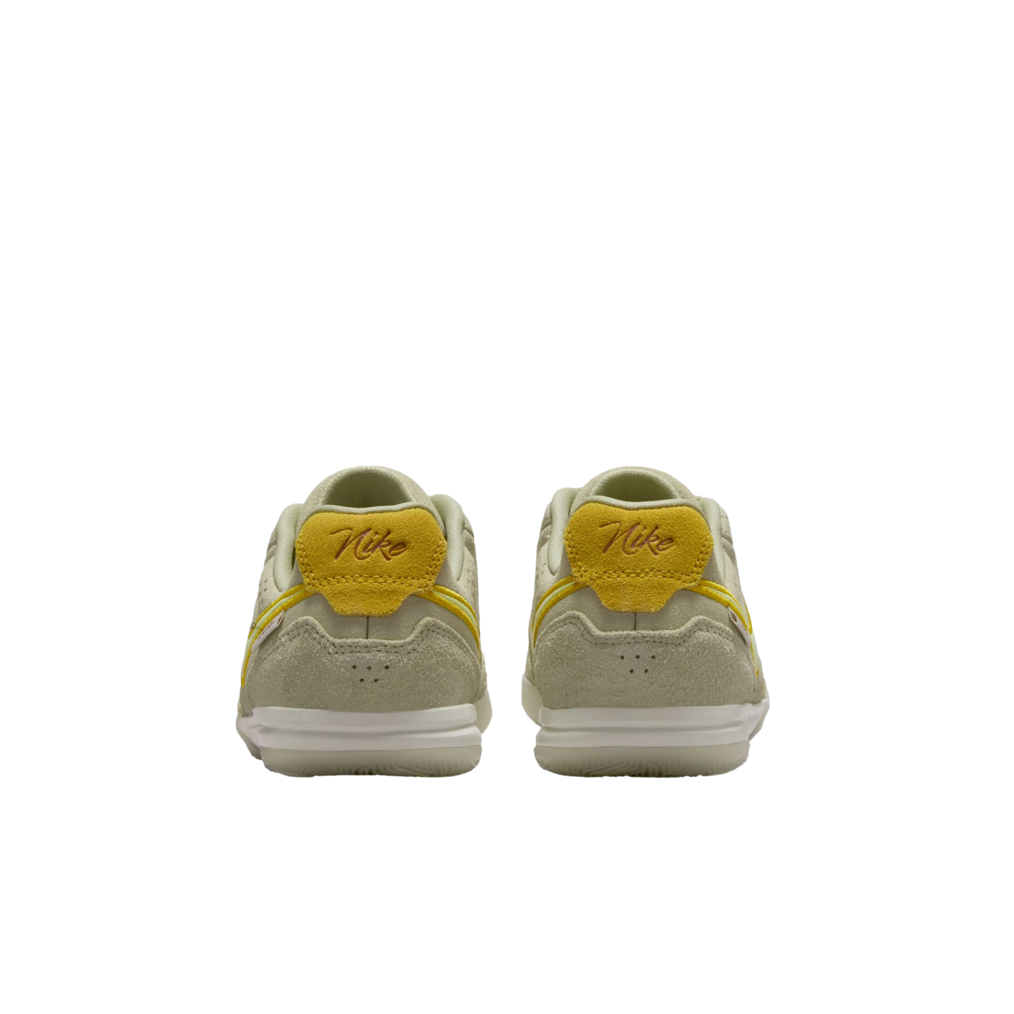 A rear view of two light green Nike sneakers with yellow accents and script "Nike" heel tabs, set against a solid black background.