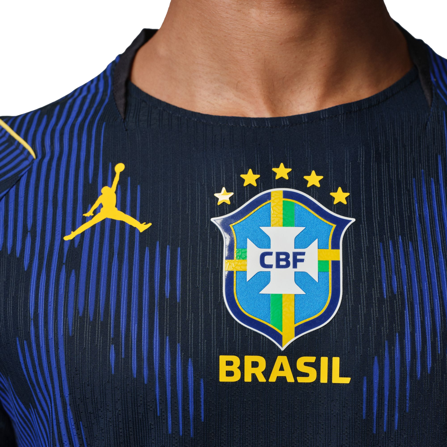 Close-up of a dark blue Brazil soccer jersey with a yellow Jordan logo and the CBF crest with five stars above the word "BRASIL".