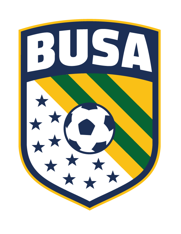 A shield-shaped logo for BUSA. The top features the word "BUSA" in bold, white block letters on a navy blue background. Below, a navy blue and white soccer ball is centered over a background of diagonal yellow and green stripes on the right and small navy blue stars on a white field on the left.