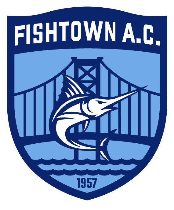 A blue and white shield-shaped logo for "FISHTOWN A.C." featuring a central white marlin leaping in front of a suspension bridge silhouette and wavy water. The year "1957" is inscribed at the bottom.