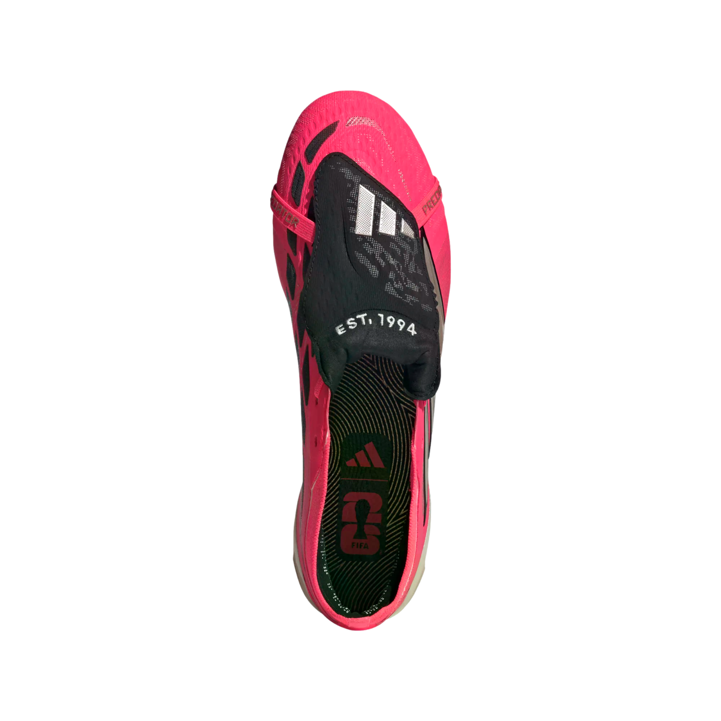 A top-down view of a bright pink Adidas Predator soccer cleat with a black fold-over tongue featuring the Adidas logo and "EST. 1994" text.