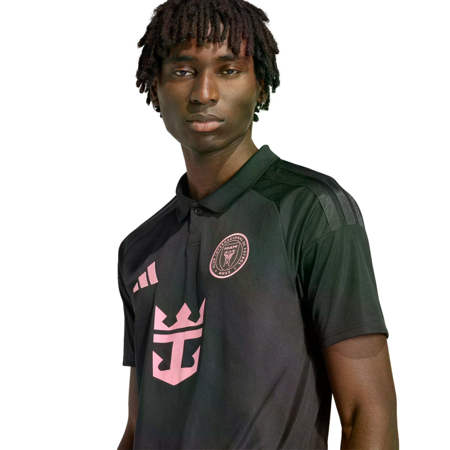Young man with dreadlocks in a black and pink Inter Miami CF jersey featuring the Adidas, team crest, and Royal Caribbean logos, against a black background.