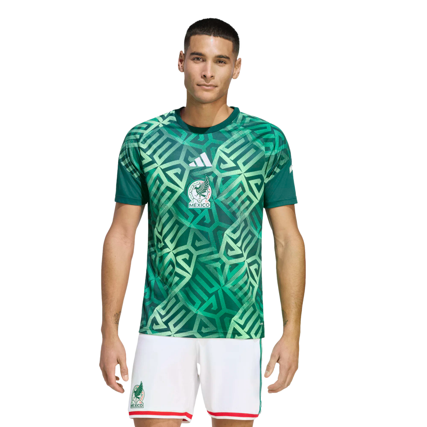 Male model wearing a Mexico national football team kit by Adidas, featuring a green geometric patterned jersey and white shorts.