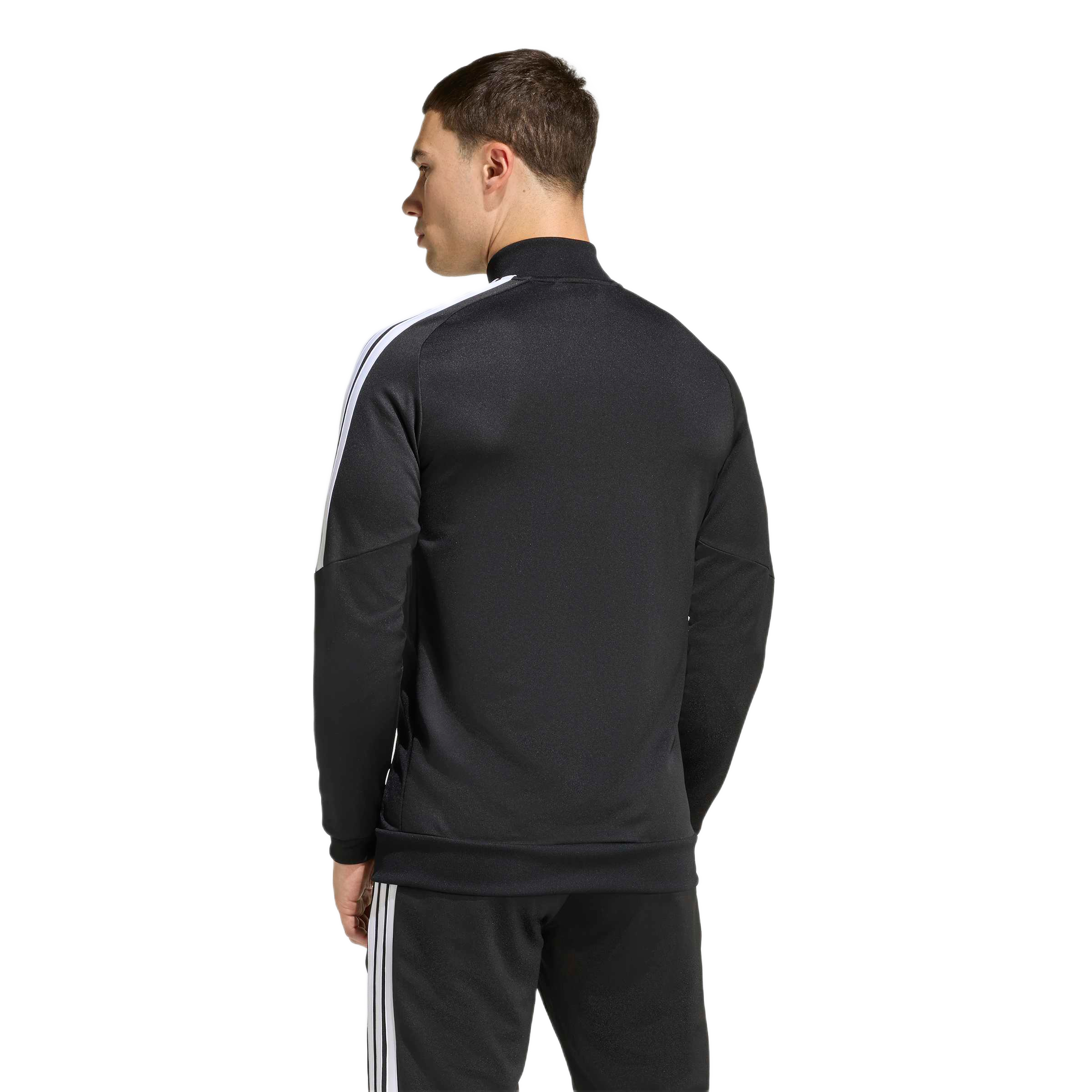 Rear view of a man wearing a black track jacket with white stripes on the shoulders and matching black pants, standing against a plain background.
