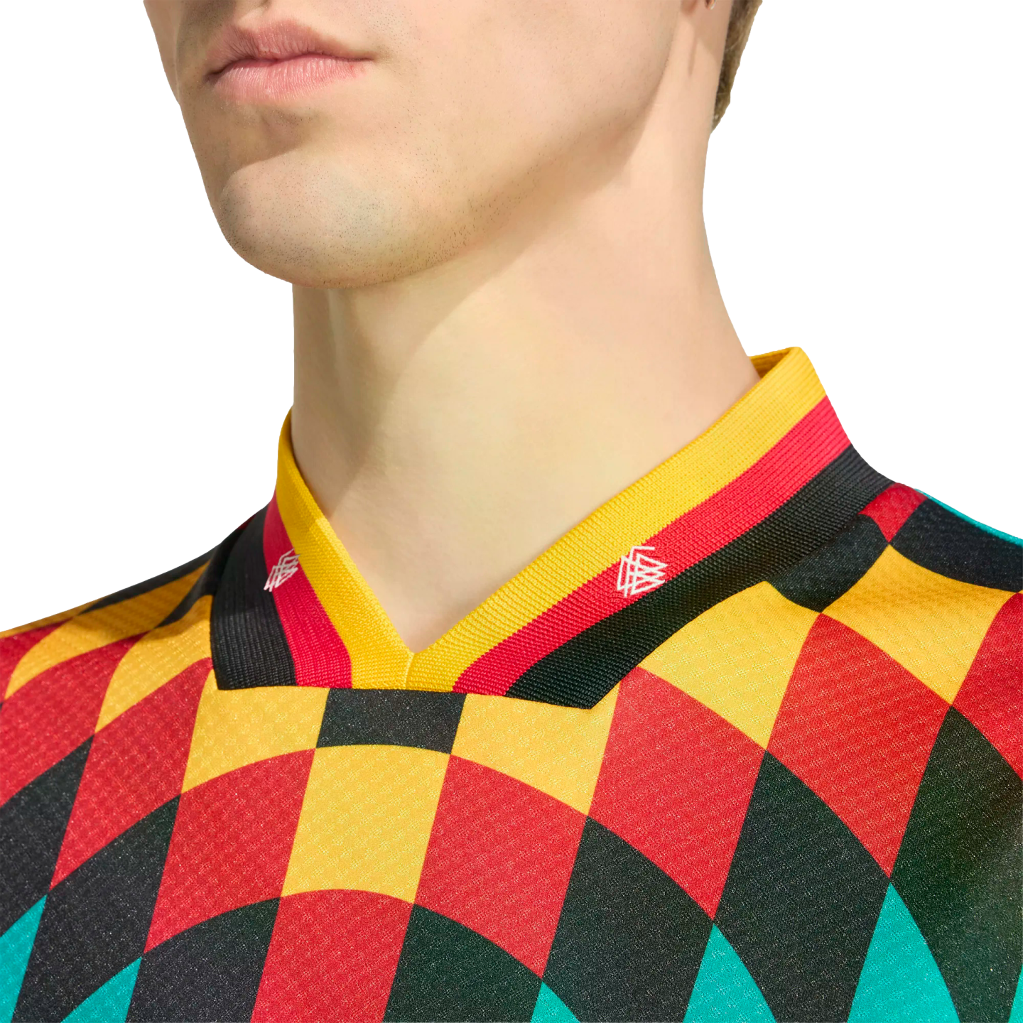 Close-up of a person wearing a vibrant harlequin-patterned jersey in red, yellow, black, and teal, featuring a German flag-colored striped collar.