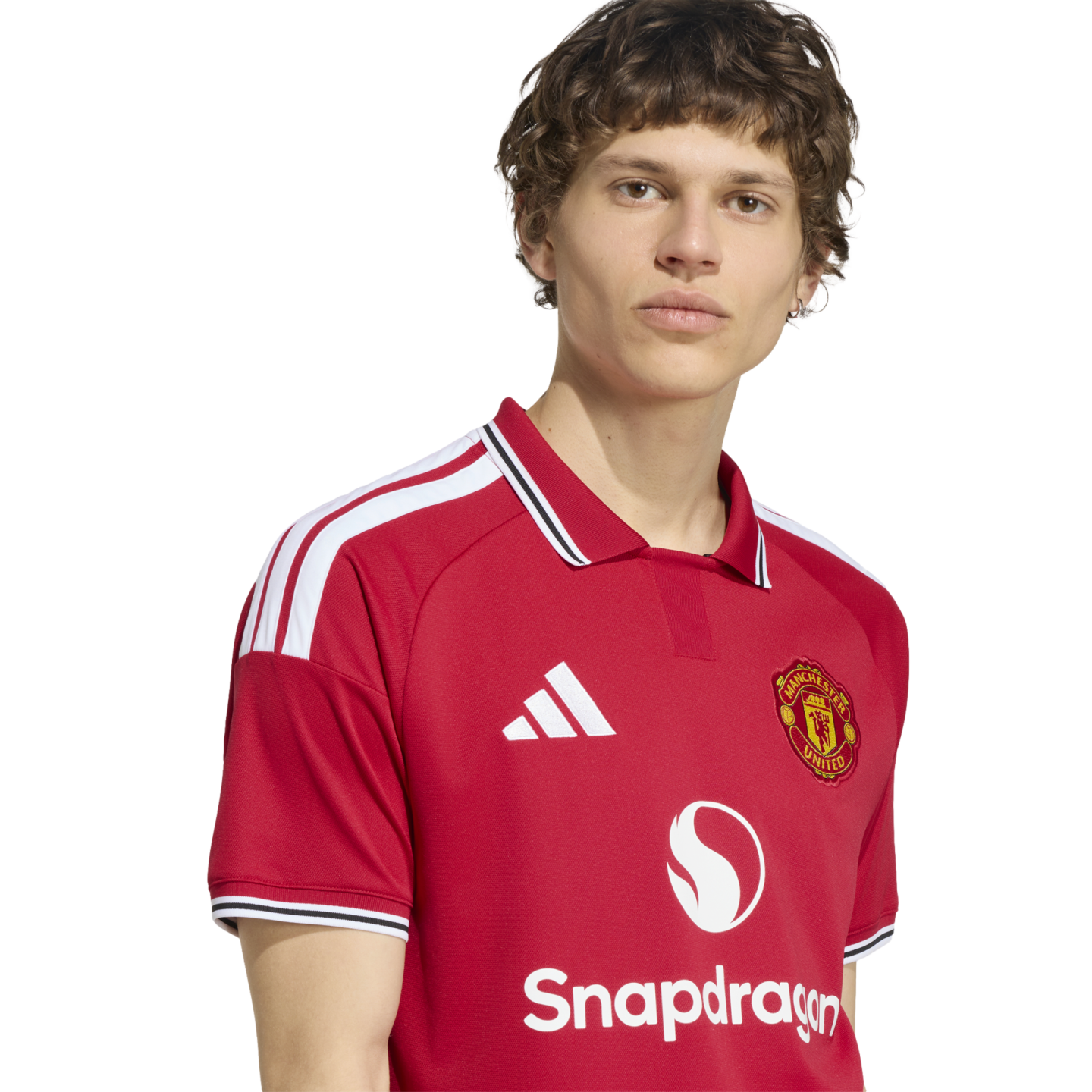 A young man wearing a red Manchester United home jersey with a white collar and Snapdragon sponsor logo against a white background.