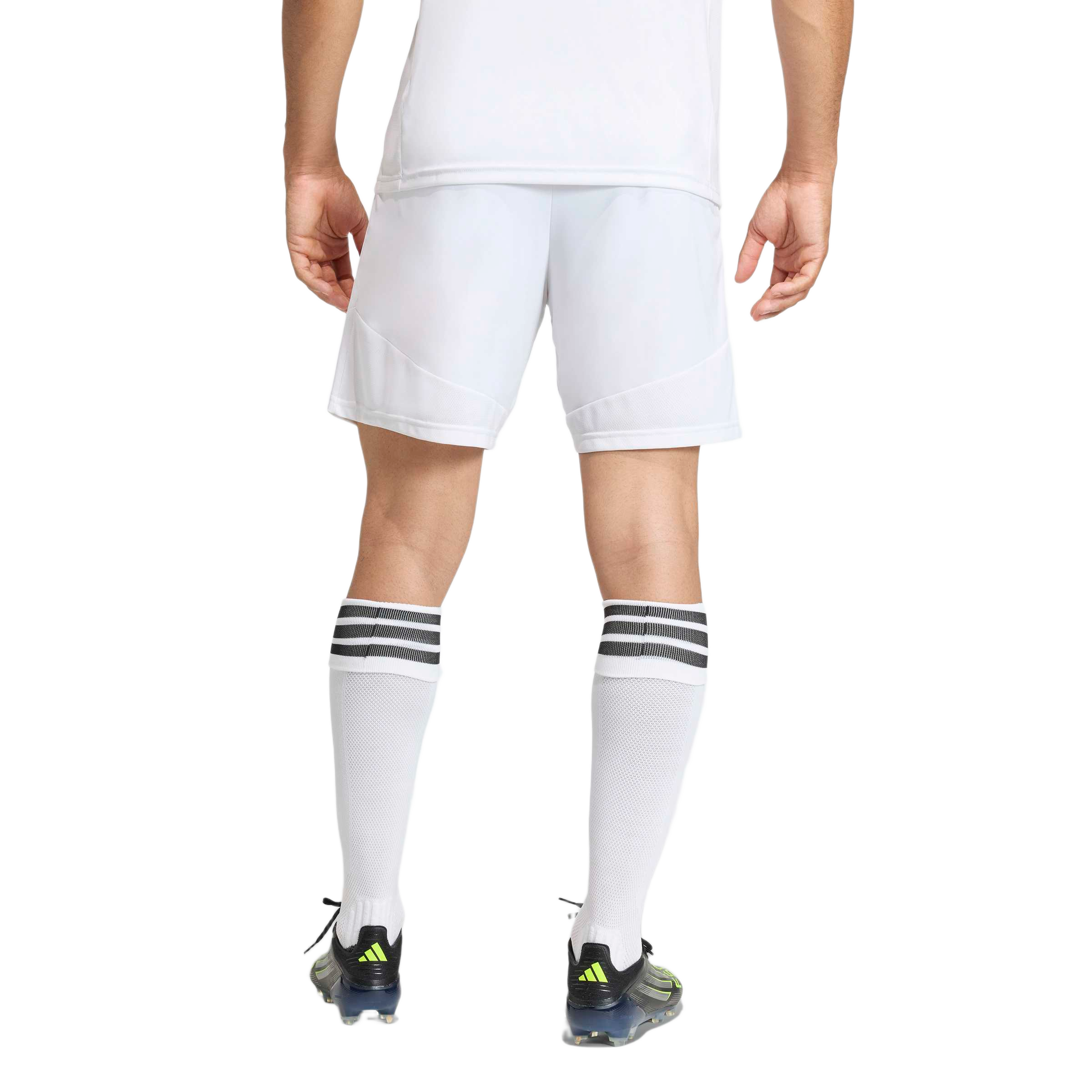 Back view of a person wearing white soccer shorts, white socks with black stripes, and black and neon green soccer cleats against a plain background.