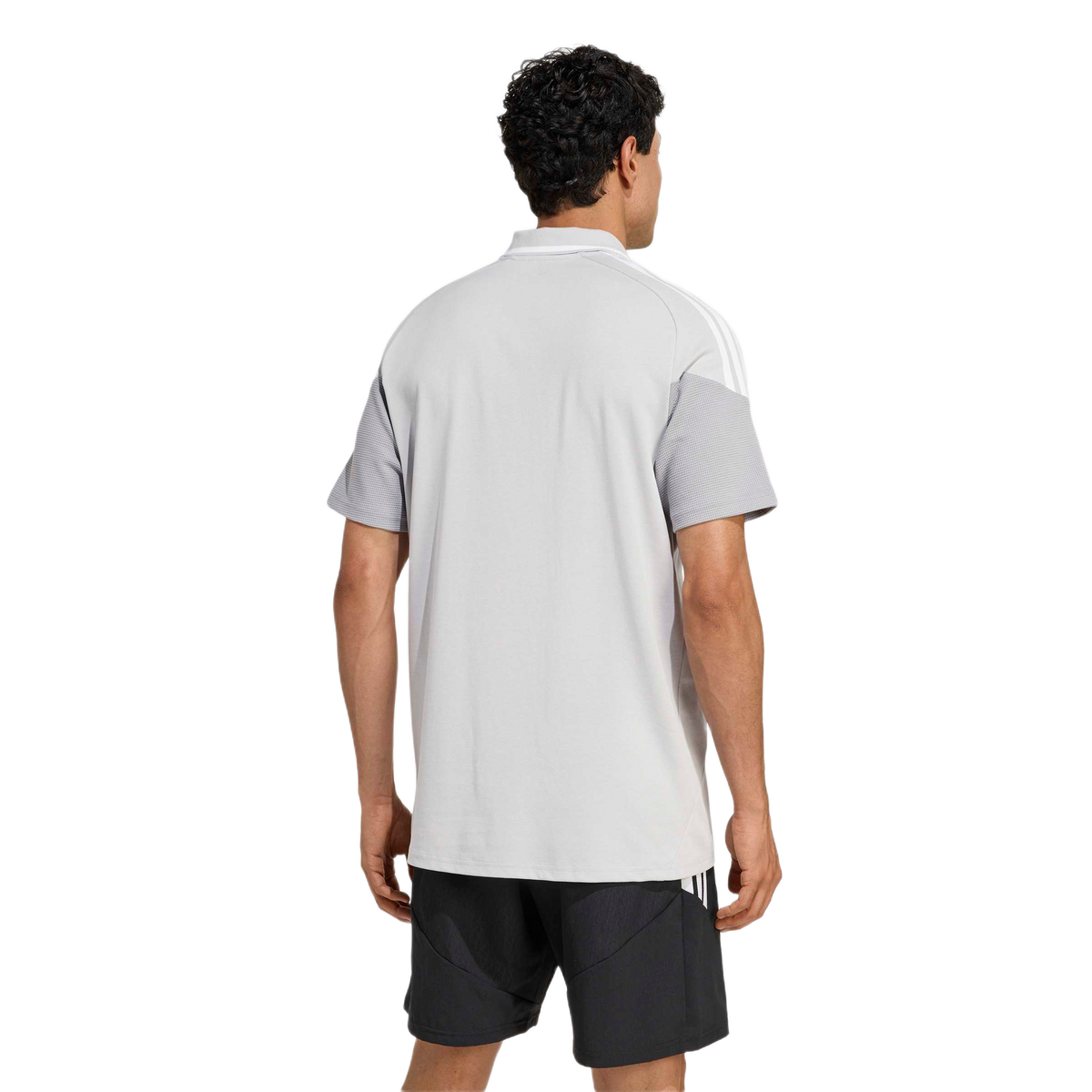 Back view of a man wearing a light grey polo shirt with white shoulder stripes and textured sleeves, paired with black athletic shorts against a plain background.