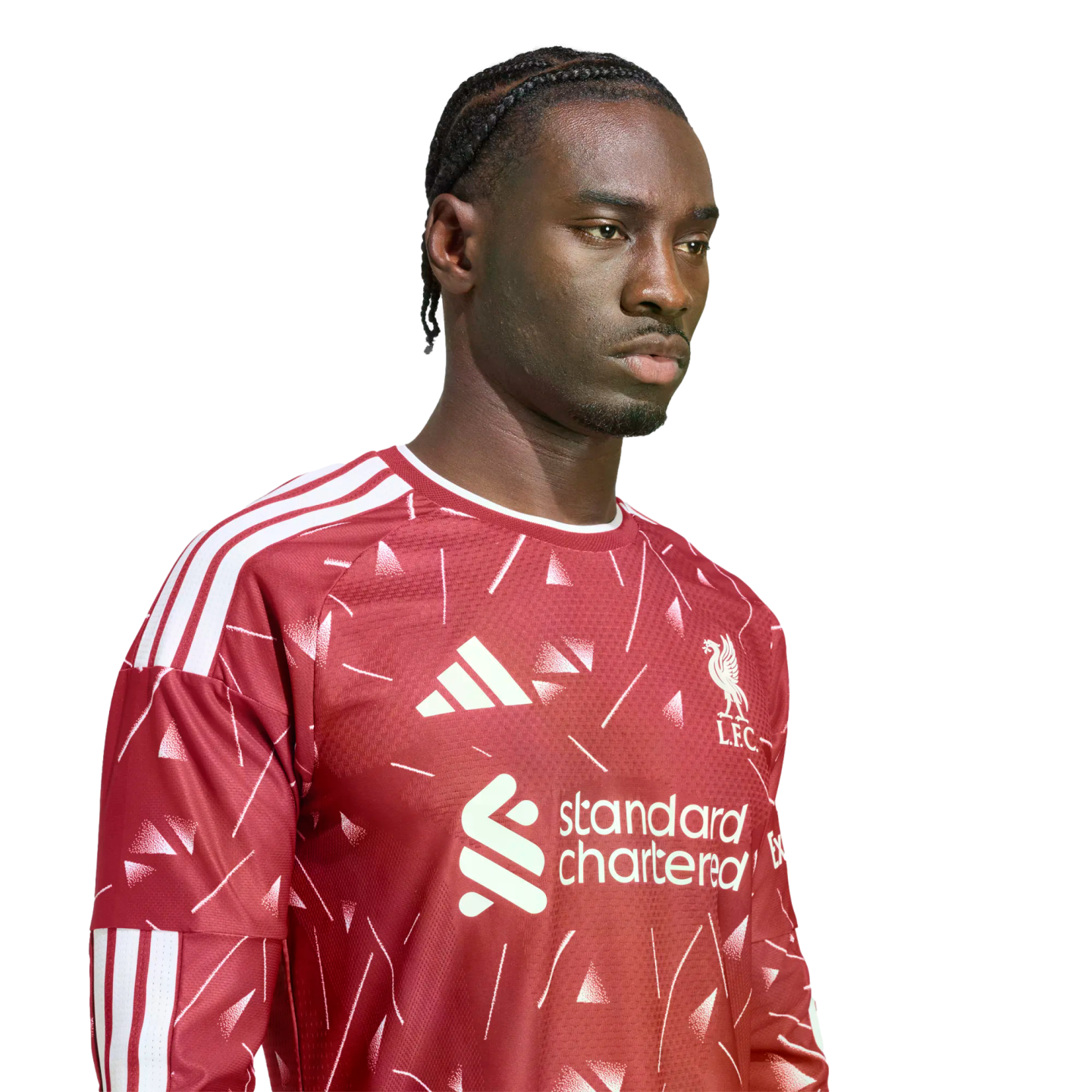 A man with braided hair wearing a patterned red Liverpool FC jersey against a white background.