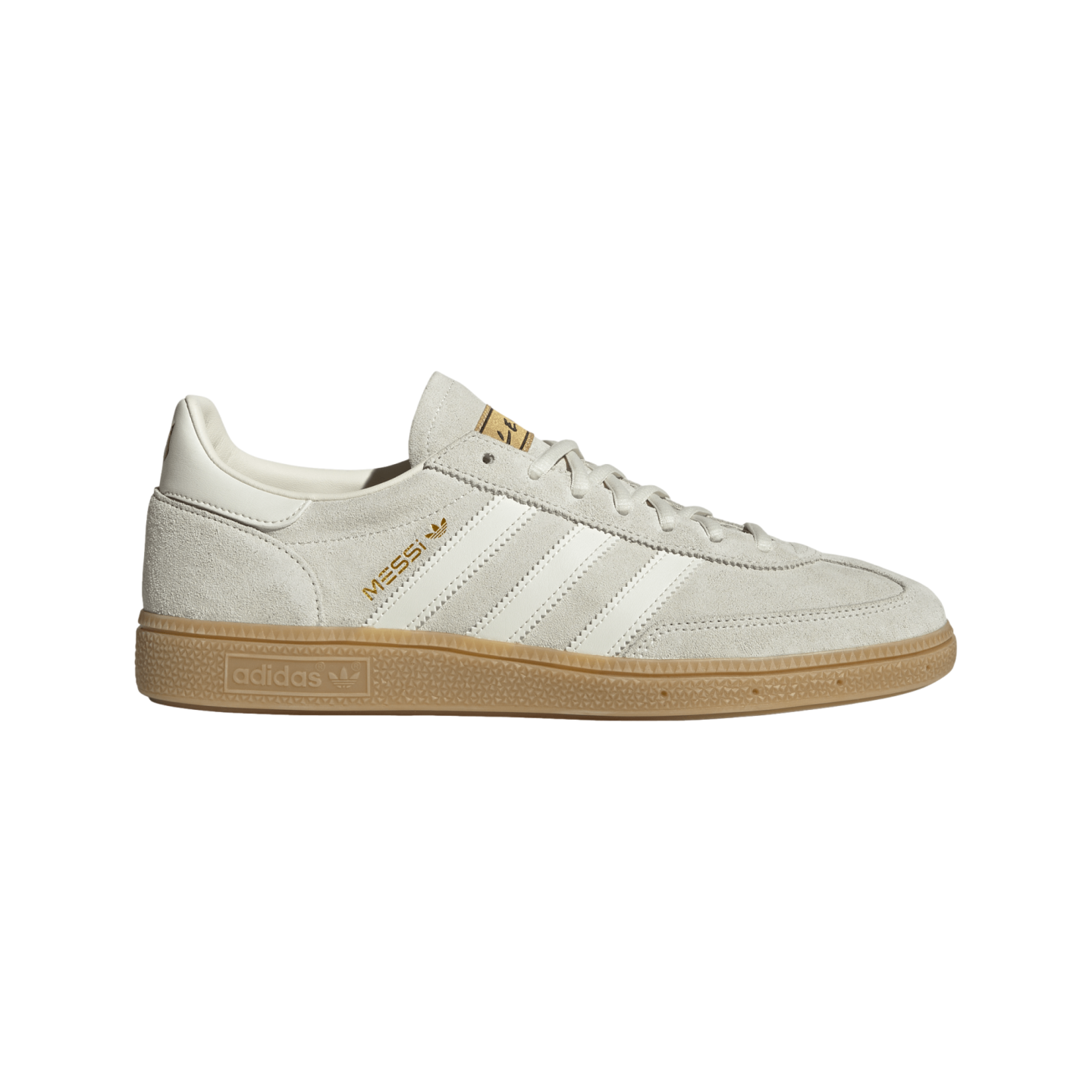 A light grey suede Adidas sneaker featuring white stripes, a gum sole, and "MESSI" in gold lettering on the side.