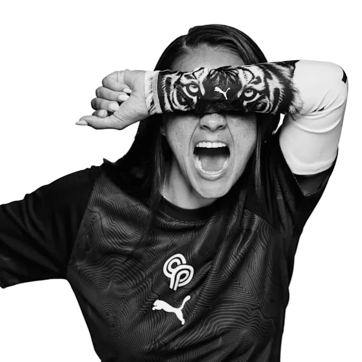 Black and white image of a woman shouting, eyes covered by her arm wearing a tiger-eye print sleeve. She wears a patterned Puma soccer jersey with a "CP" logo.
