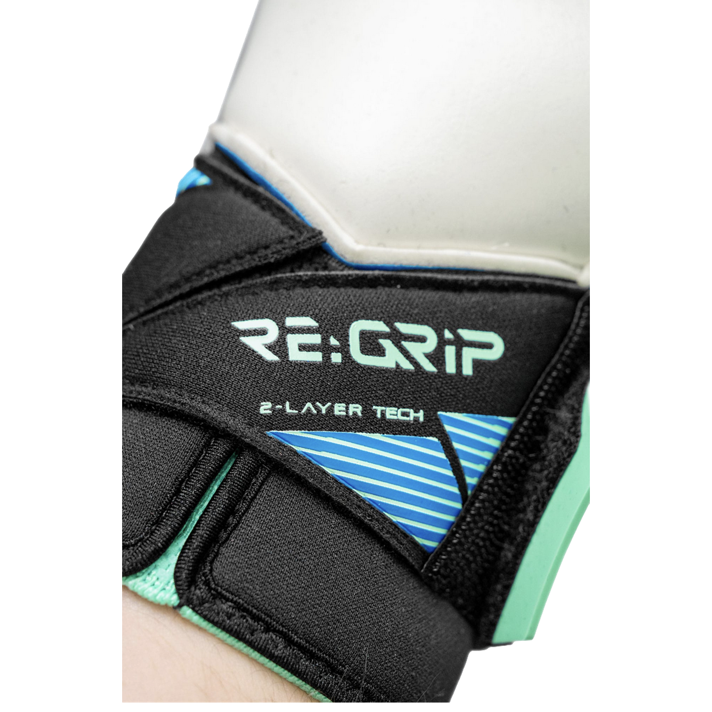 Close-up of a goalkeeper glove's black wrist strap with "RE:GRIP" and "2-LAYER TECH" printed in light green above a blue striped graphic.