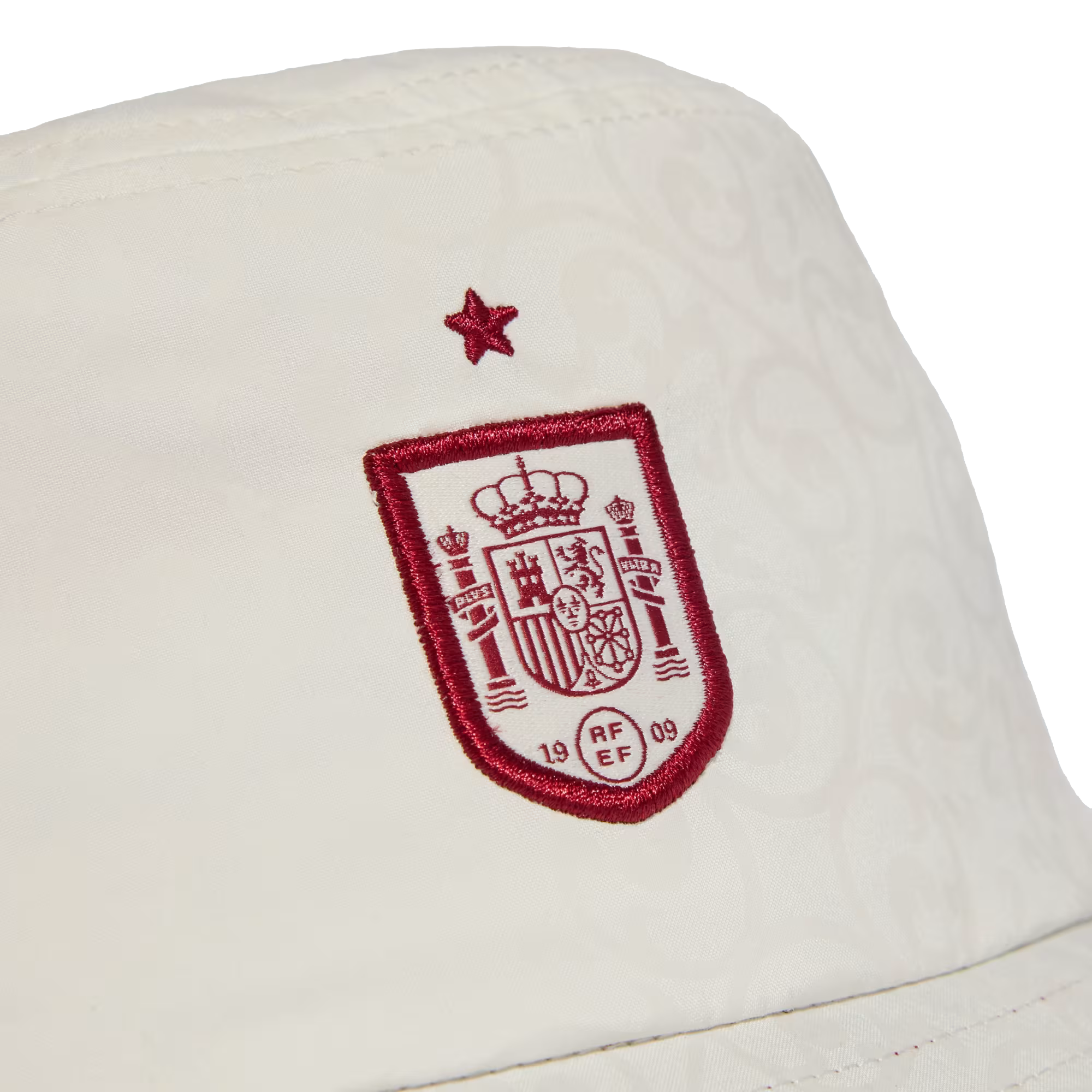 Close-up of a white bucket hat featuring the embroidered red and white Spain national football team crest with a red star above it.