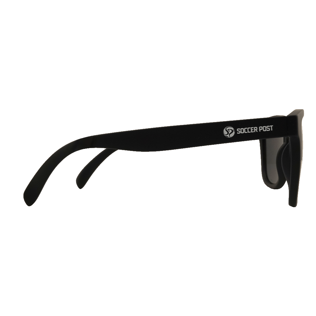 Side profile of black sunglasses with a white "SOCCER POST" logo on the temple, set against a solid green background.
